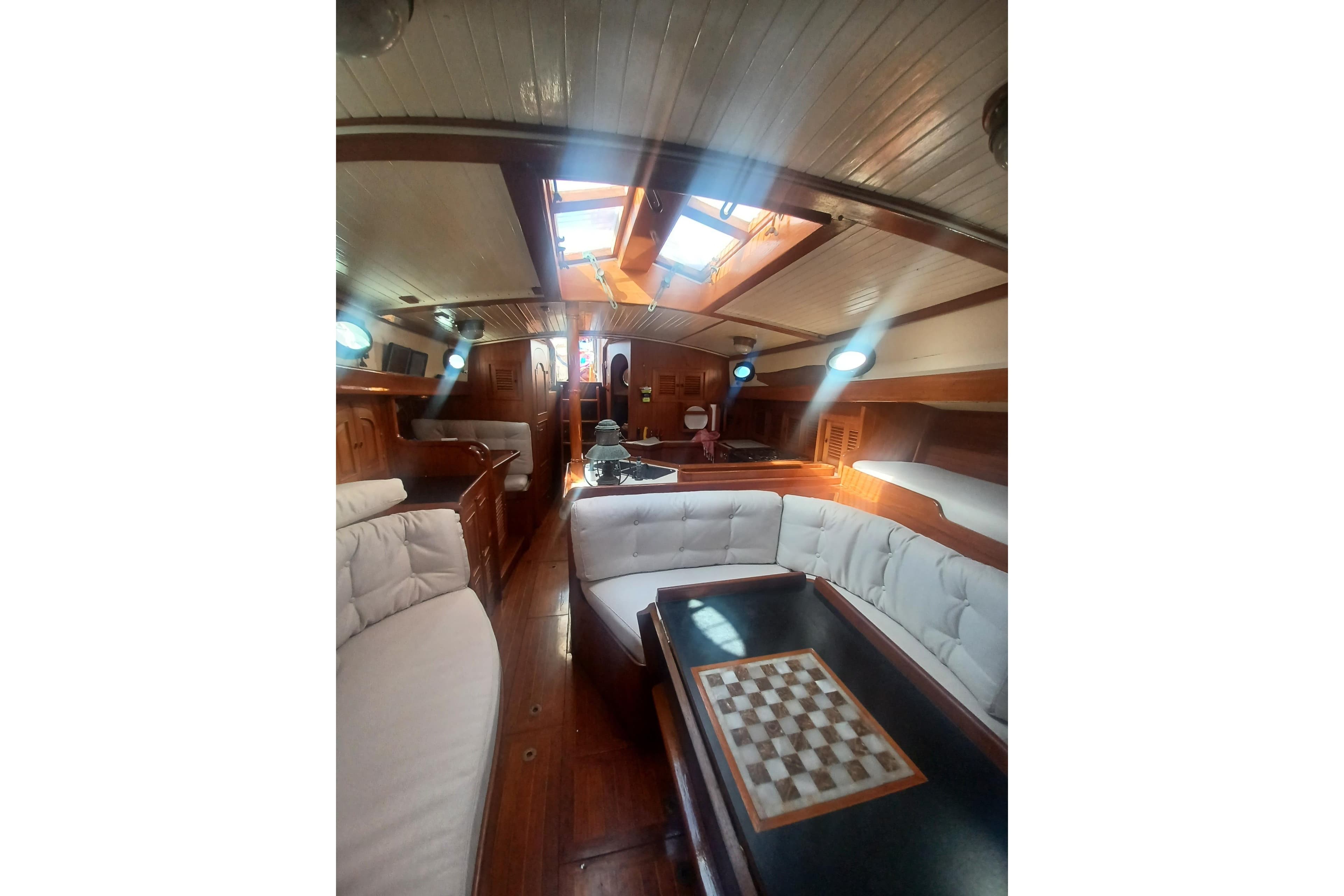 Interior of 1980 Hans Christian 43 sailboat with cozy seating and chessboard table.