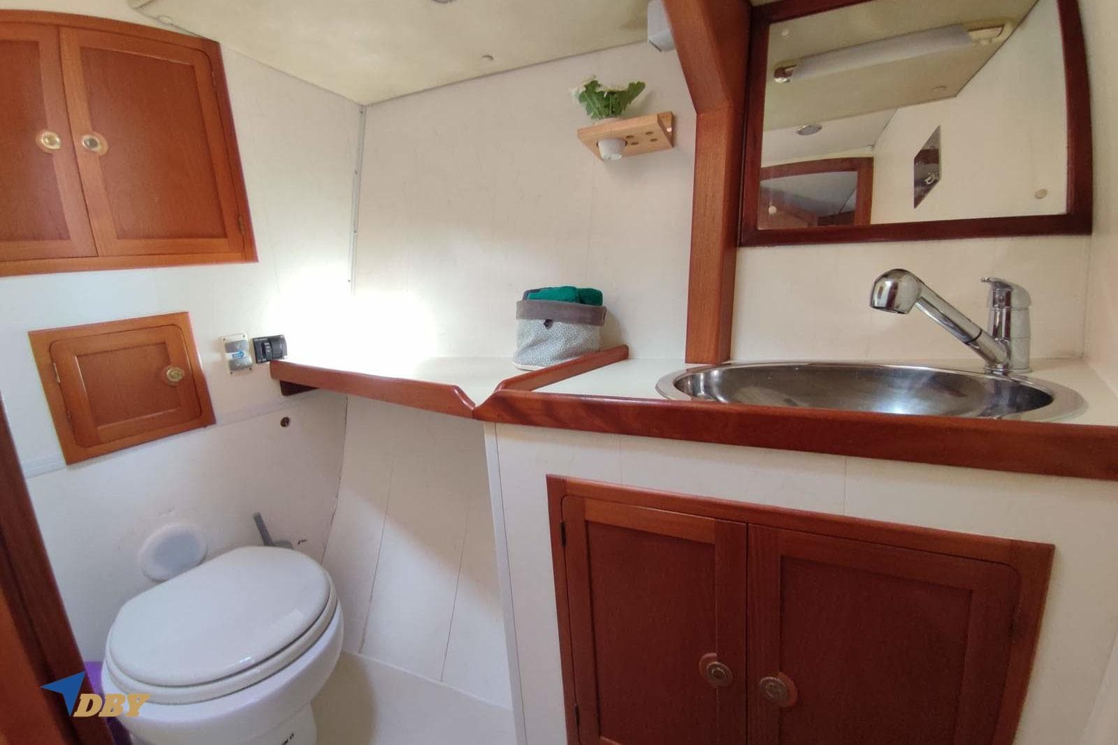 2006 Dudley Dix 43 yacht bathroom with wooden cabinets, sink, and toilet.