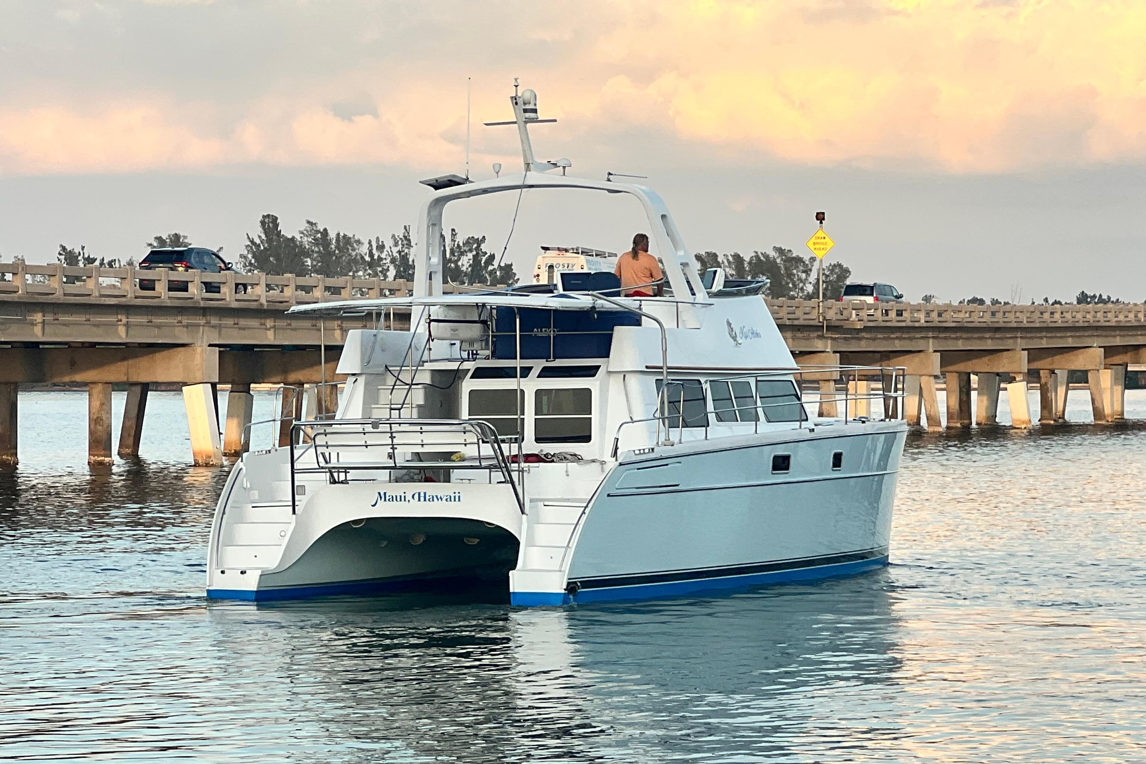 2007 PDQ MV41 catamaran cruising near a bridge in Maui, Hawaii.
