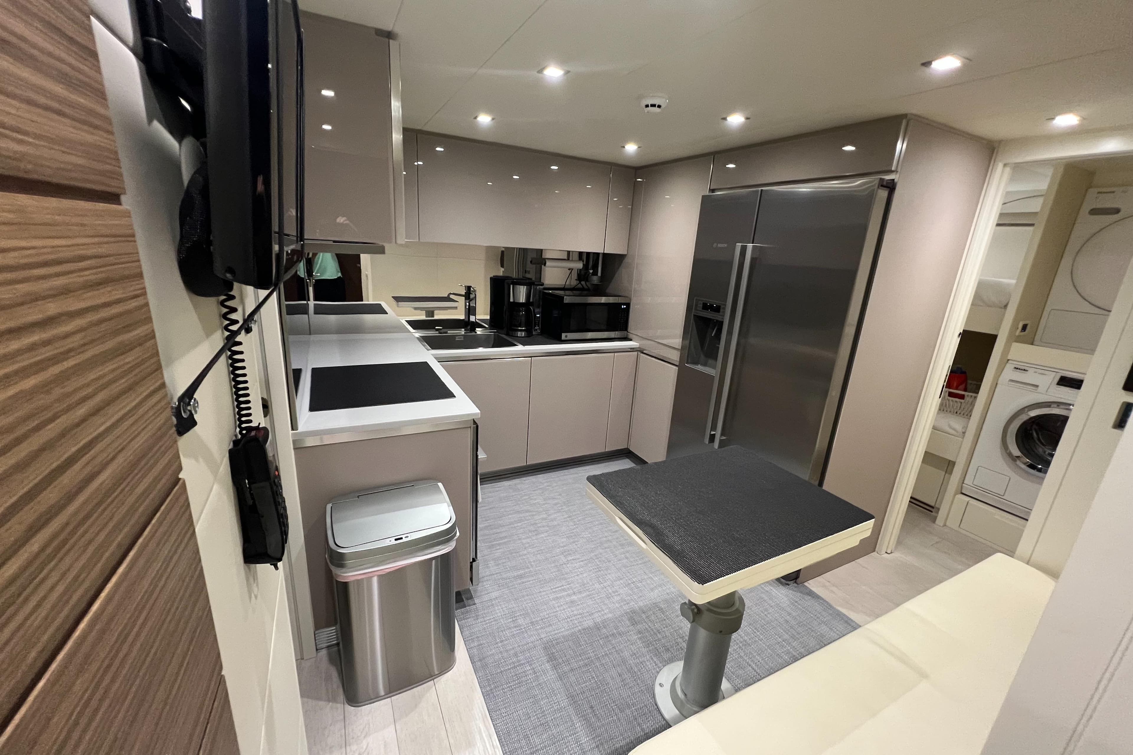 Modern kitchen interior of 2017 Pershing 92 Motor Yacht with sleek appliances and dining area.