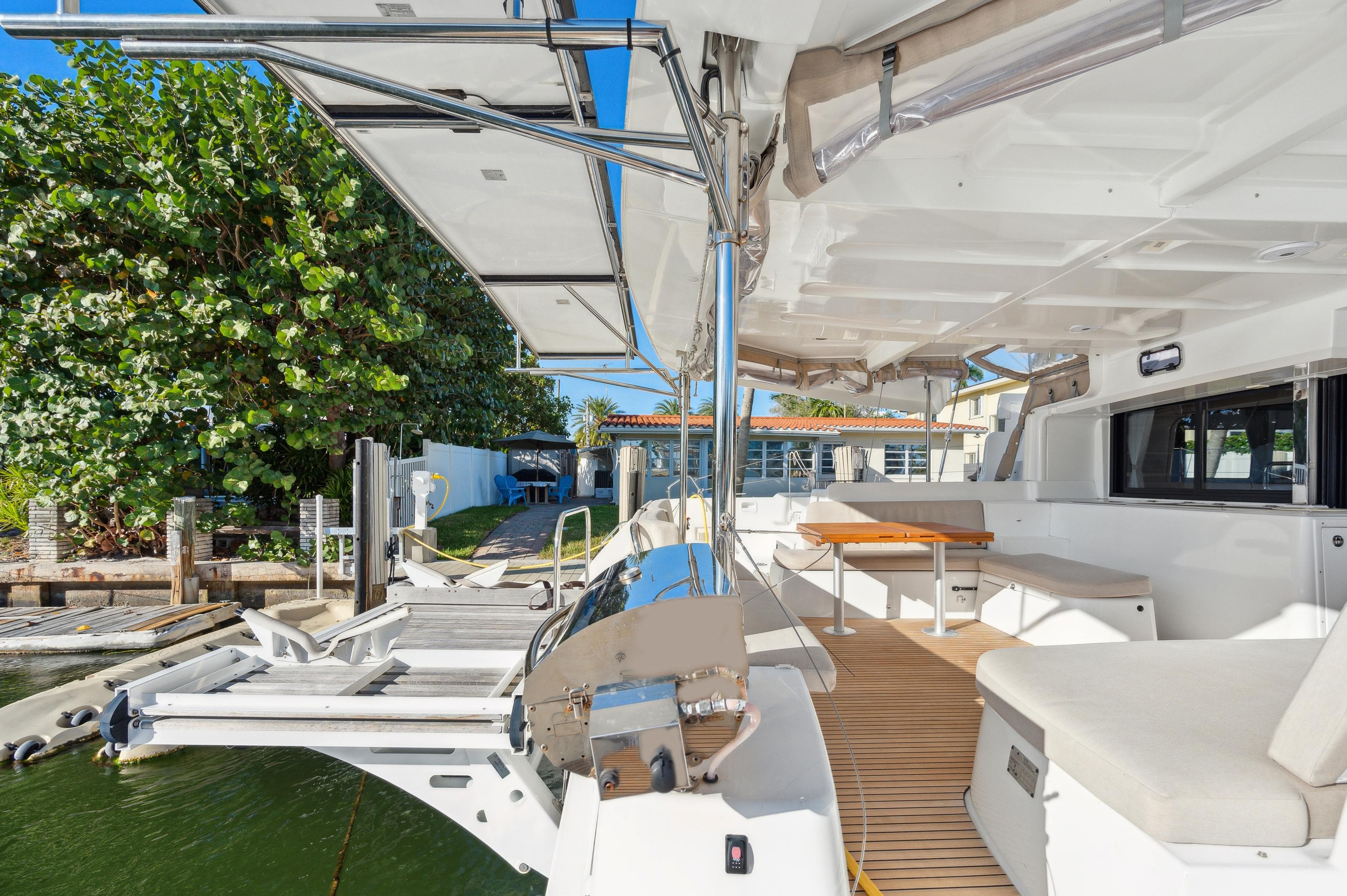 2022 Lagoon 46 catamaran docked, featuring spacious deck and seating area under clear blue sky.