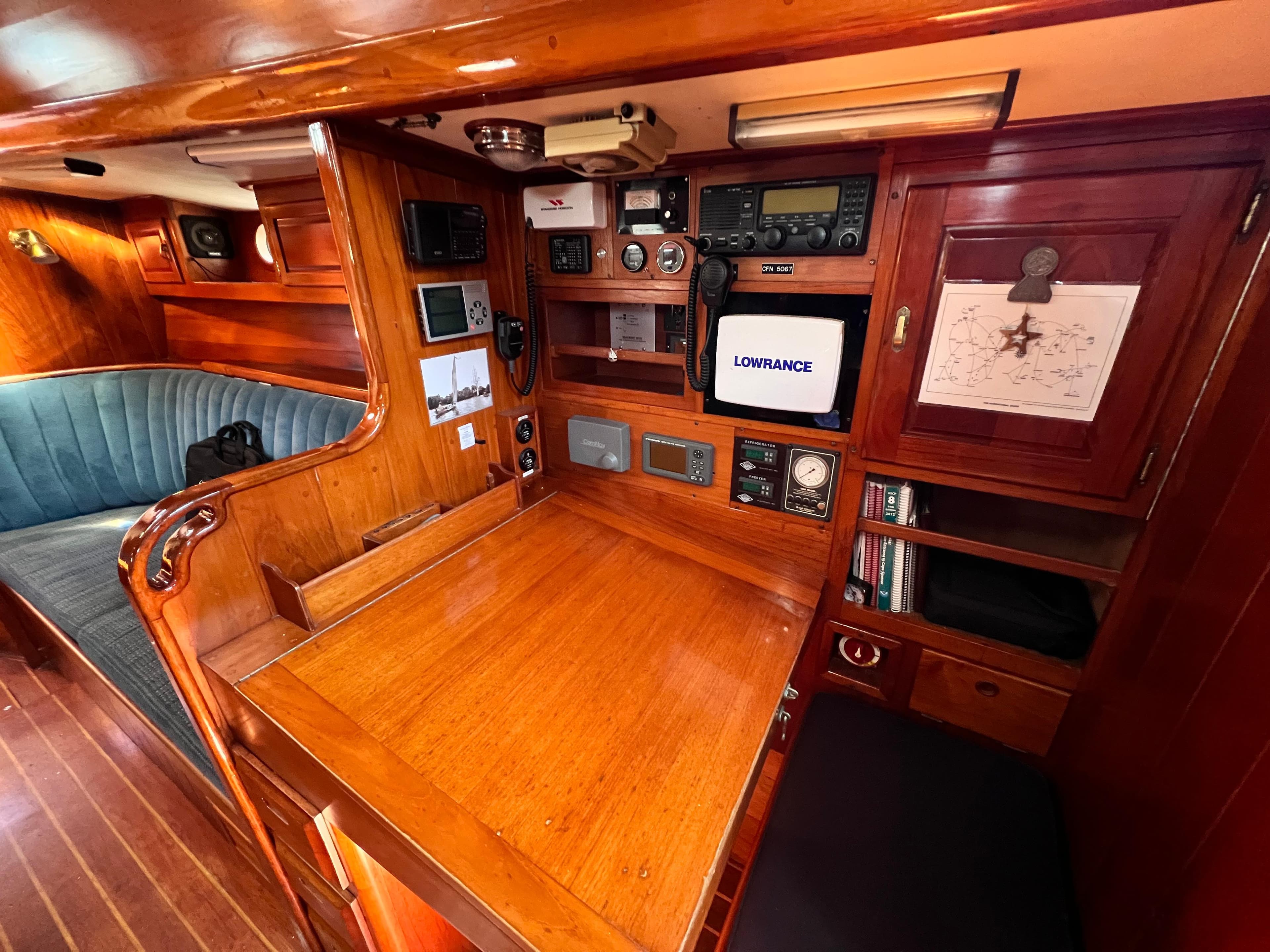 Navigation station inside 1987 Reliance 45 yacht with wooden finish and electronic equipment.