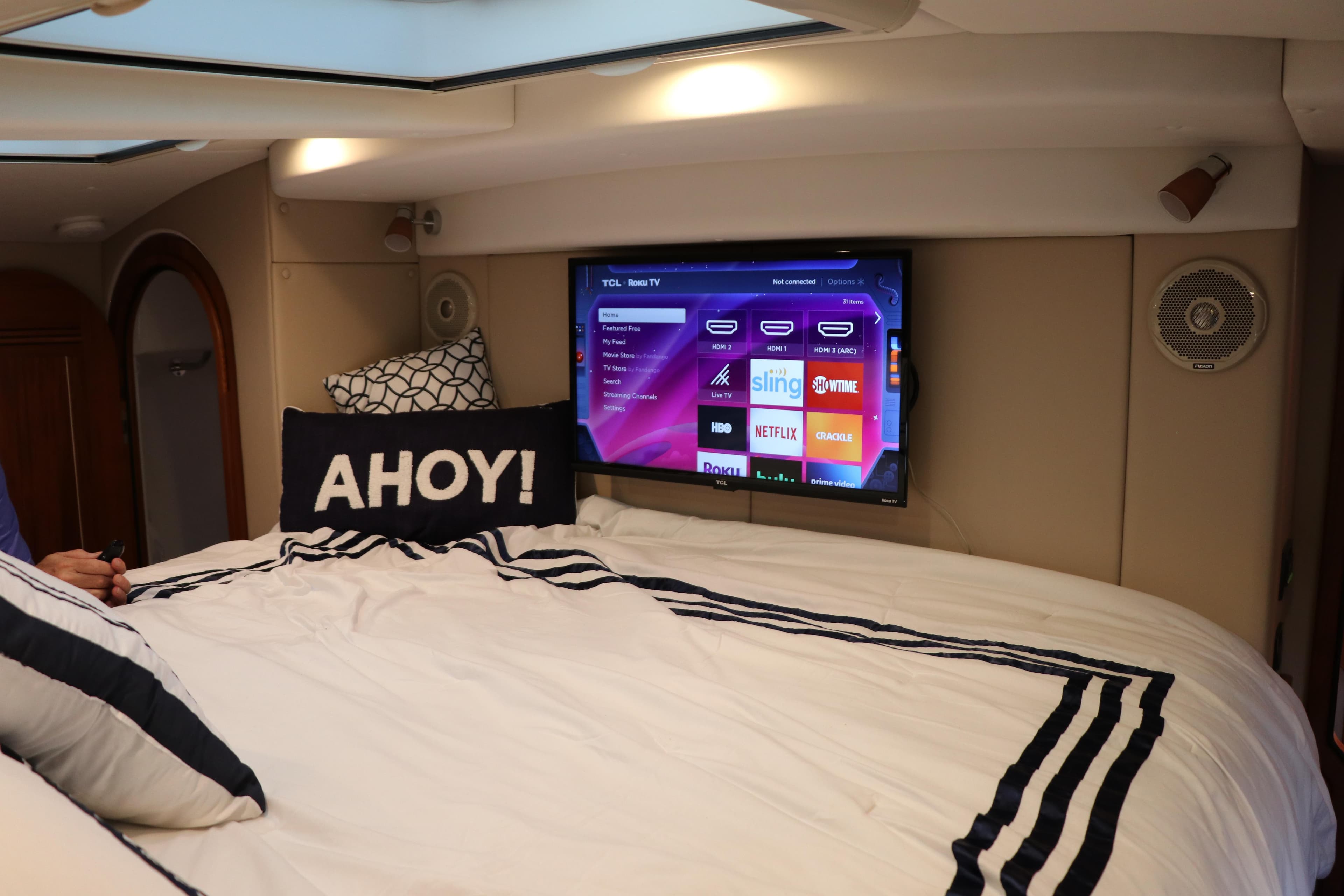 Luxurious bedroom in 2026 Aspen C128 Flybridge yacht with TV and nautical decor.
