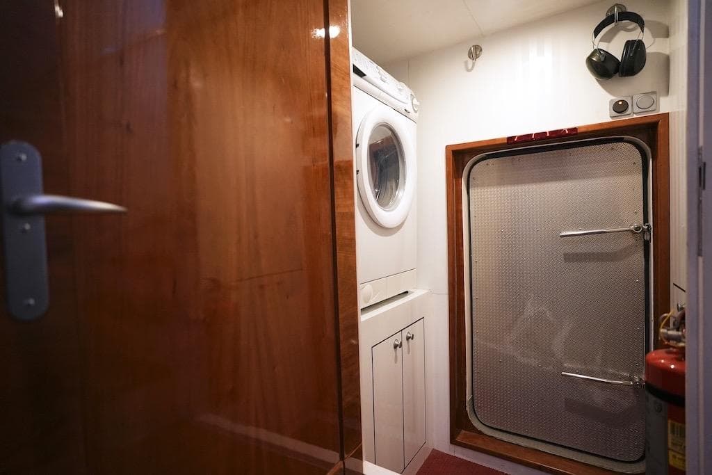 Laundry room with washer, metal door, and headphones in a 2005 Stentor 1800 model.
