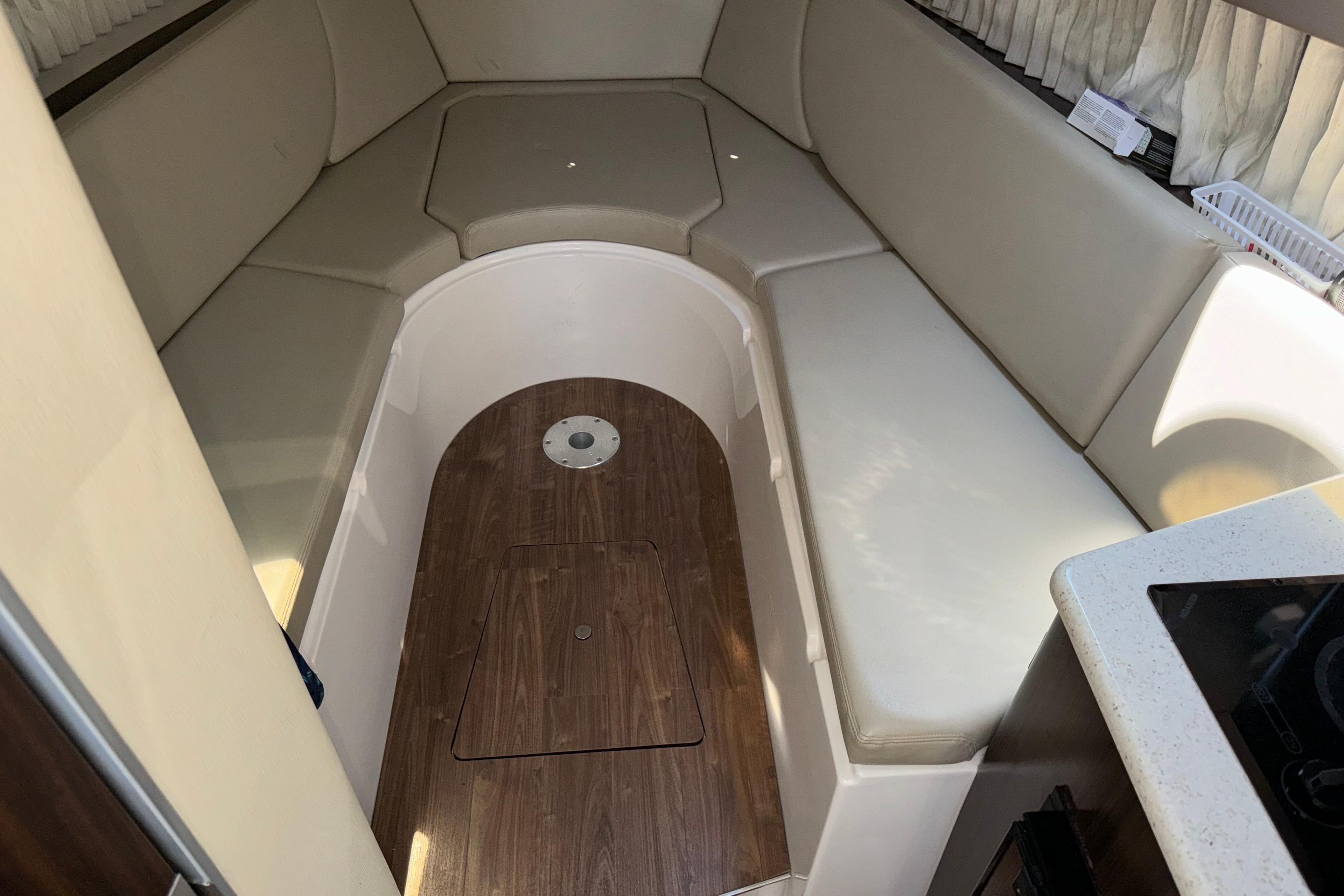 Interior cabin of 2017 Regal 28 Express boat with beige seating and wood flooring.