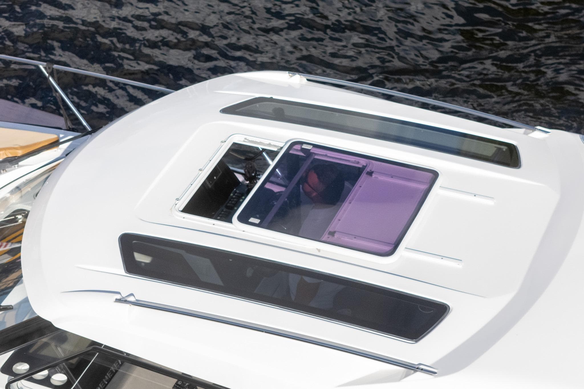 2021 Beneteau Antares 9 boat roof with open hatch, on water.