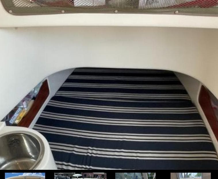 2015 Grady-White 336 Canyon cabin interior with striped bedding and stainless steel sink.