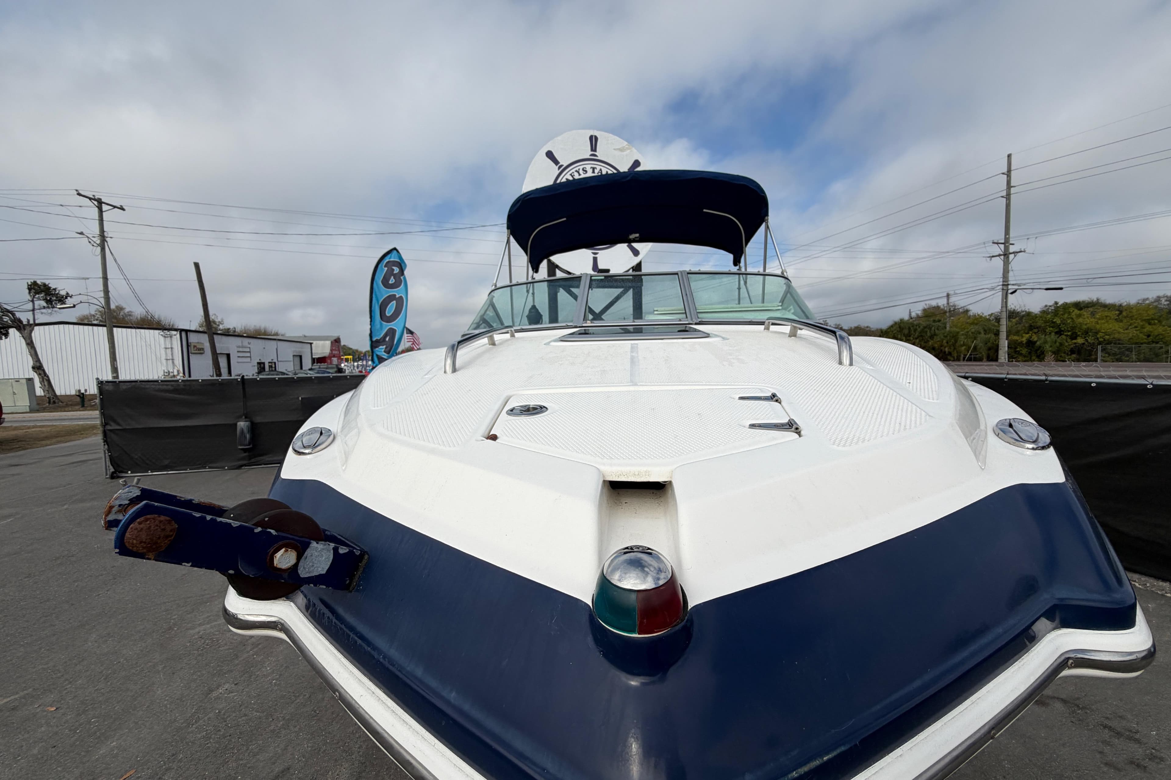 2014 Chaparral 225 SSi boat with blue and white exterior, docked outdoors.