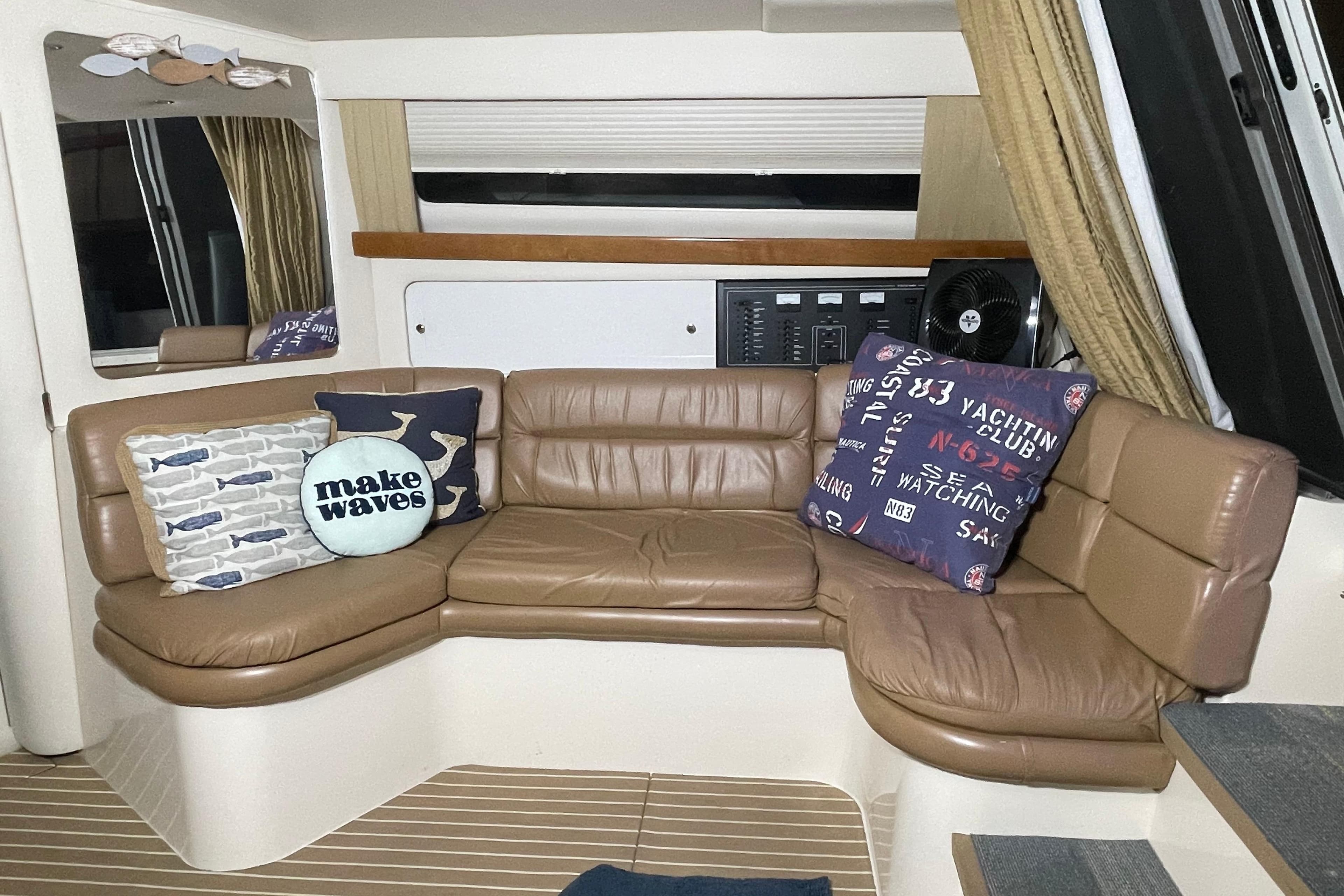 Interior of 2002 Carver 380 Santego yacht with leather seating and nautical-themed pillows.