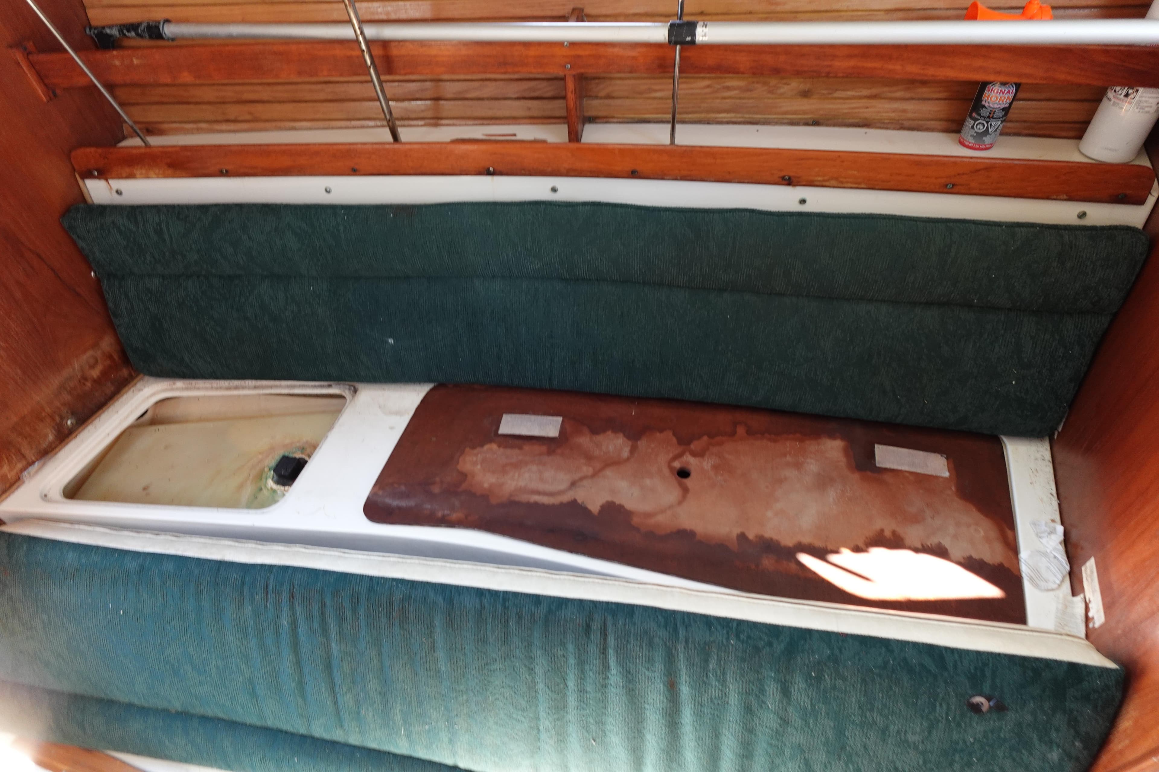 Interior of a 1997 Catalina 28 sailboat with green cushions and wooden accents.
