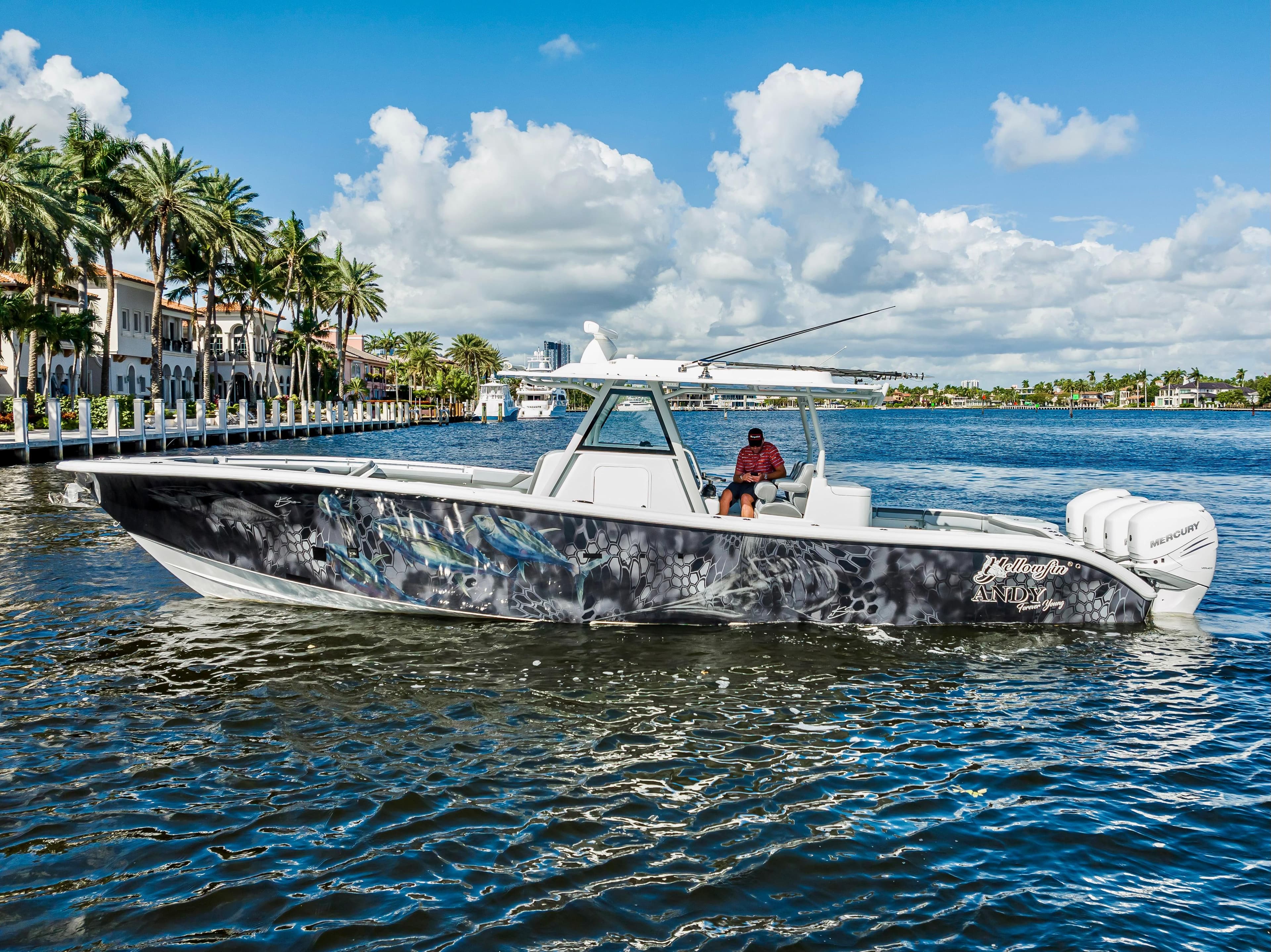 2021 Yellowfin 39 boat cruising on a sunny day near palm-lined waterfront.