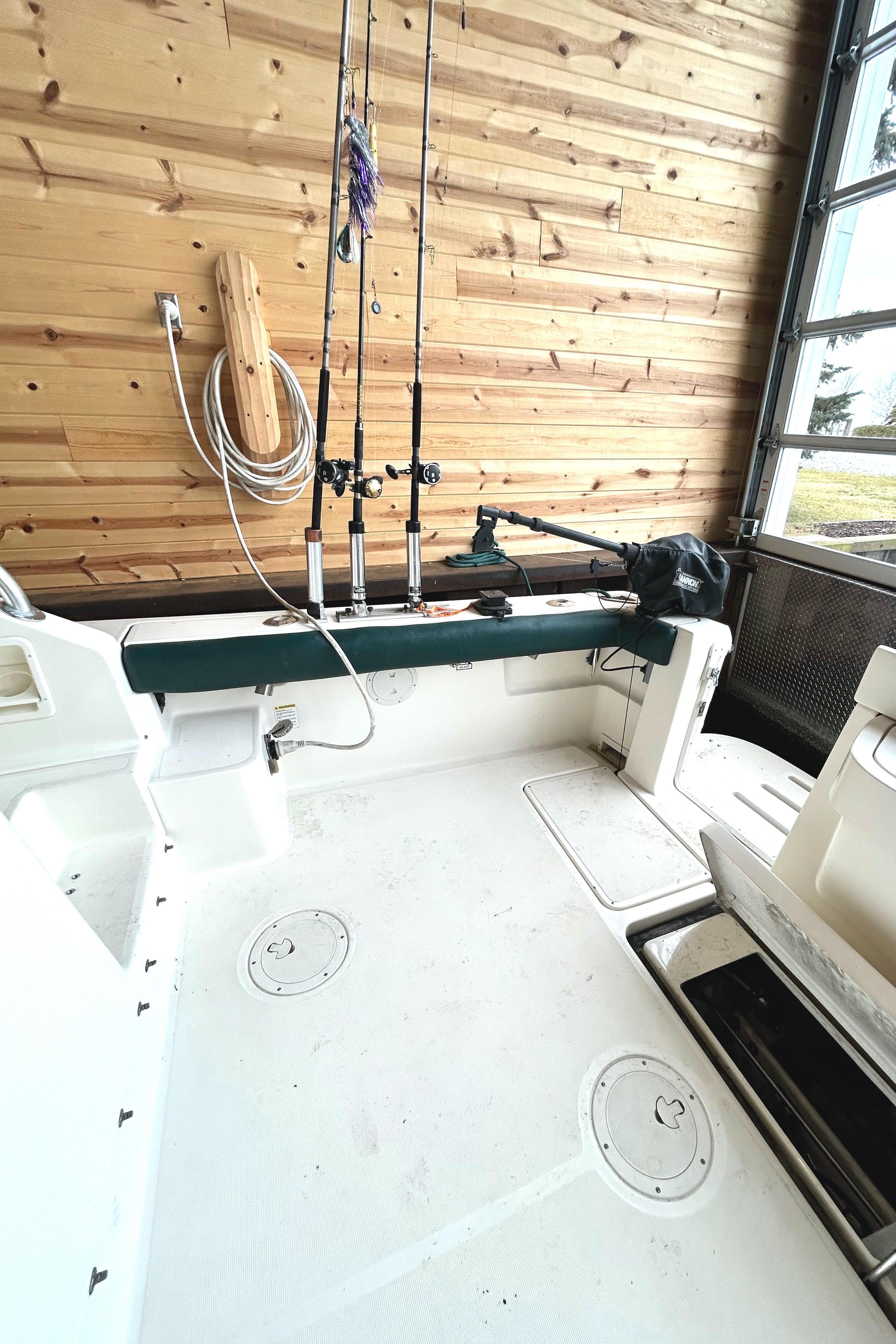 1998 Pursuit 3000 Offshore boat interior with fishing rods and wooden wall background.