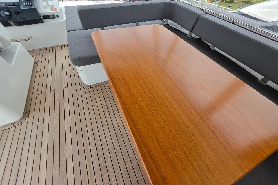 Luxurious seating area on 2024 Sirena 58 Flybridge MY yacht with wooden table.