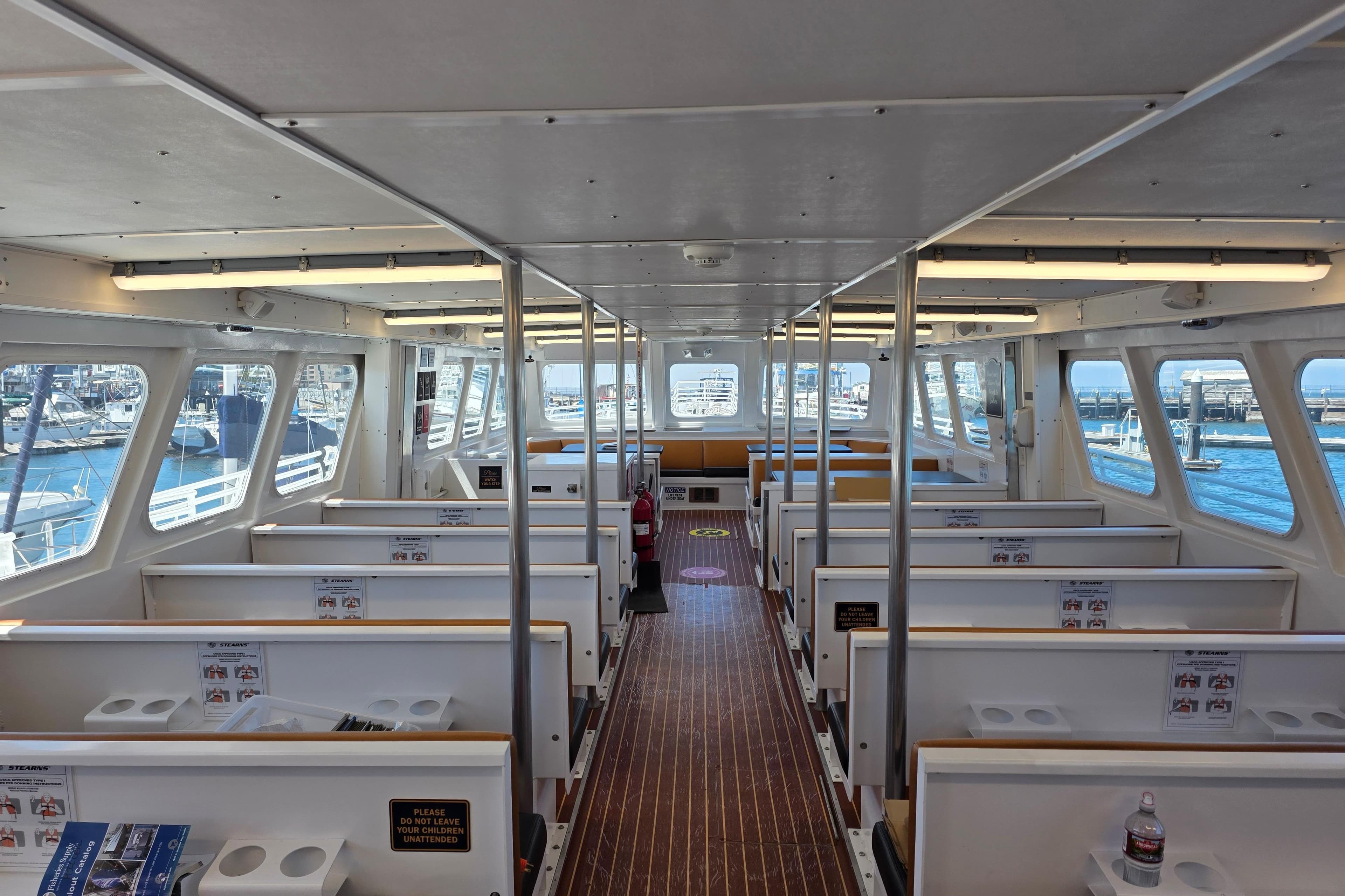 Interior of 1986 Gulf Craft Passenger boat with seating and large windows.