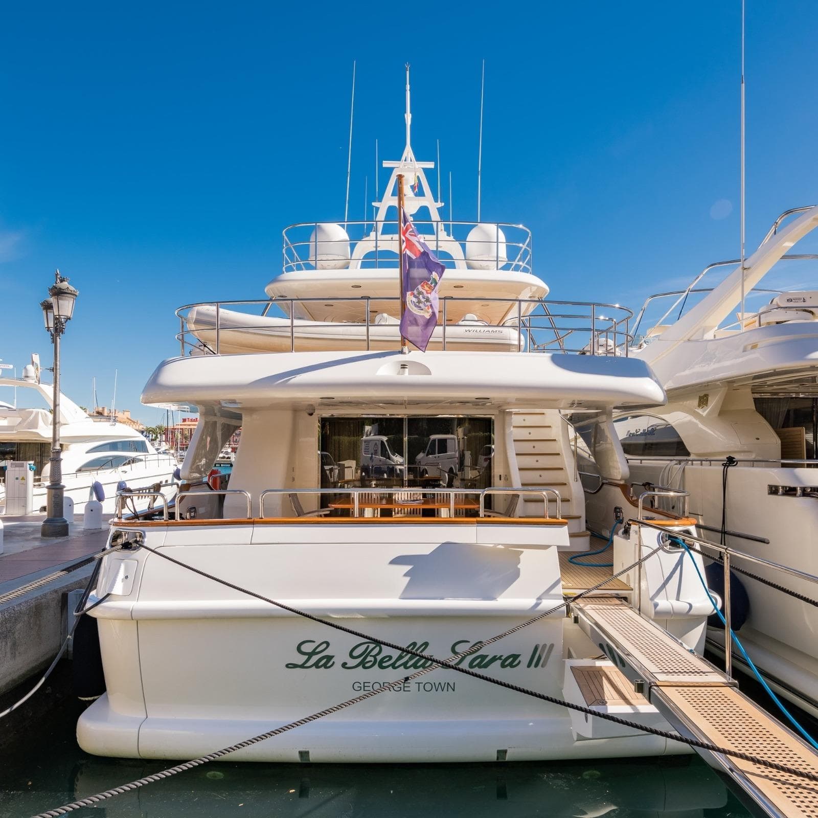 Luxury yacht "La Bella Sara II," Benetti Tradition 100, docked in sunny marina.