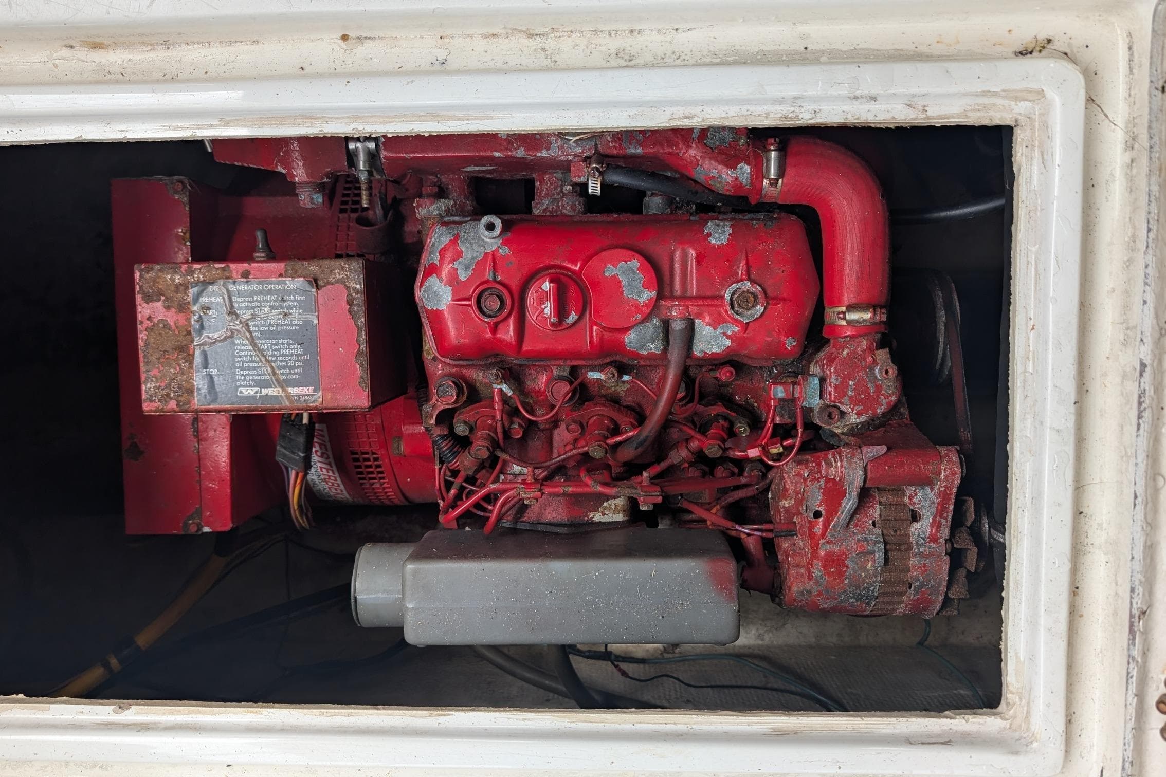 Engine compartment of a 1990 Bayliner 3888 Motoryacht, featuring a red engine.
