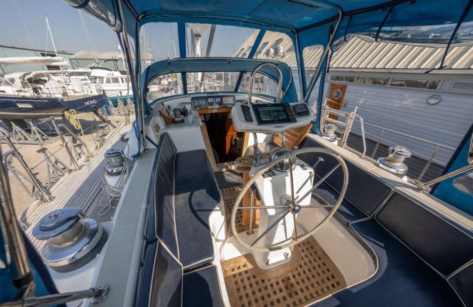 Cockpit of 2001 Hylas 54 Raised Saloon yacht with blue canopy and steering wheel.