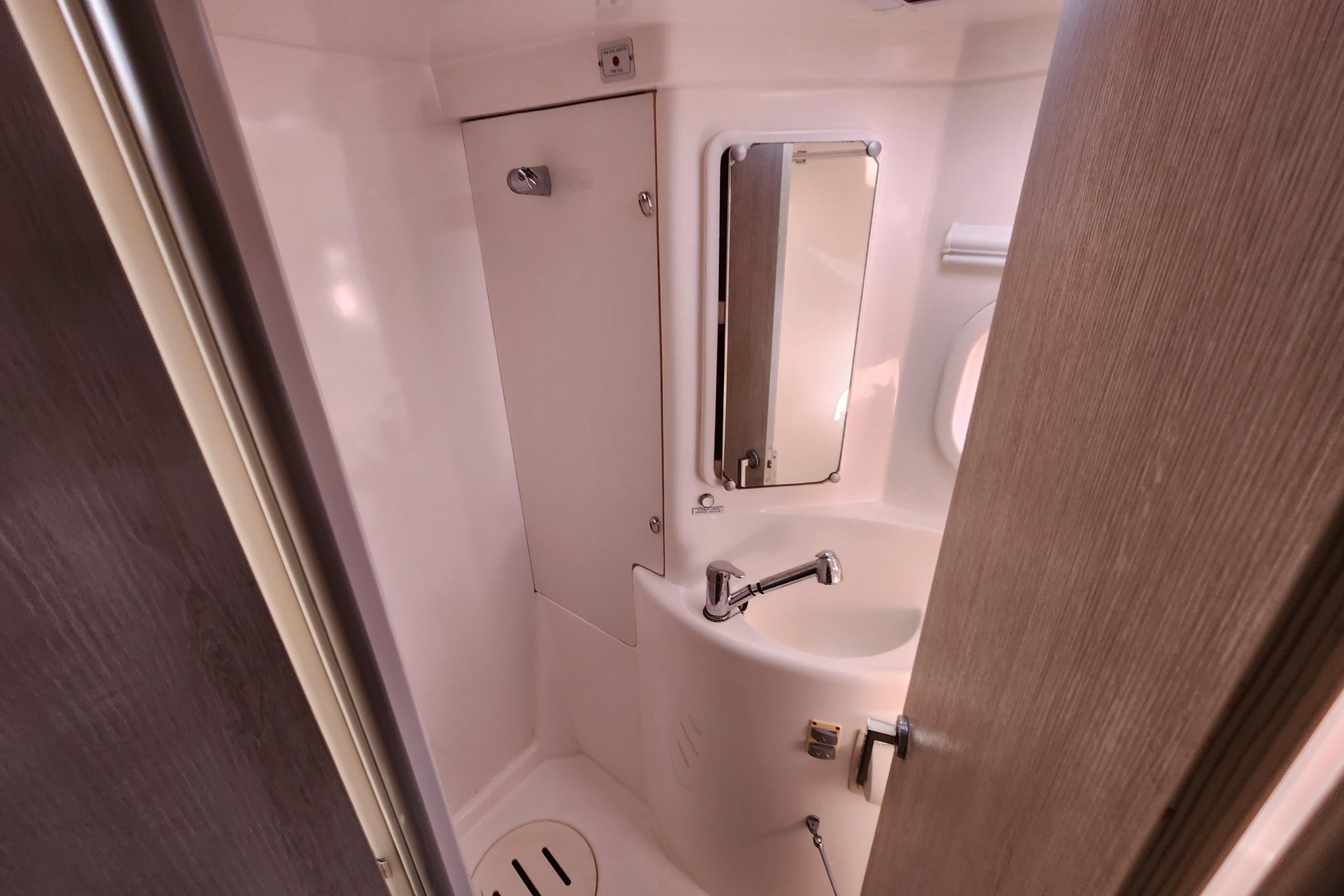 Compact bathroom in a 2015 Leopard 44 yacht, featuring a sink and mirror.
