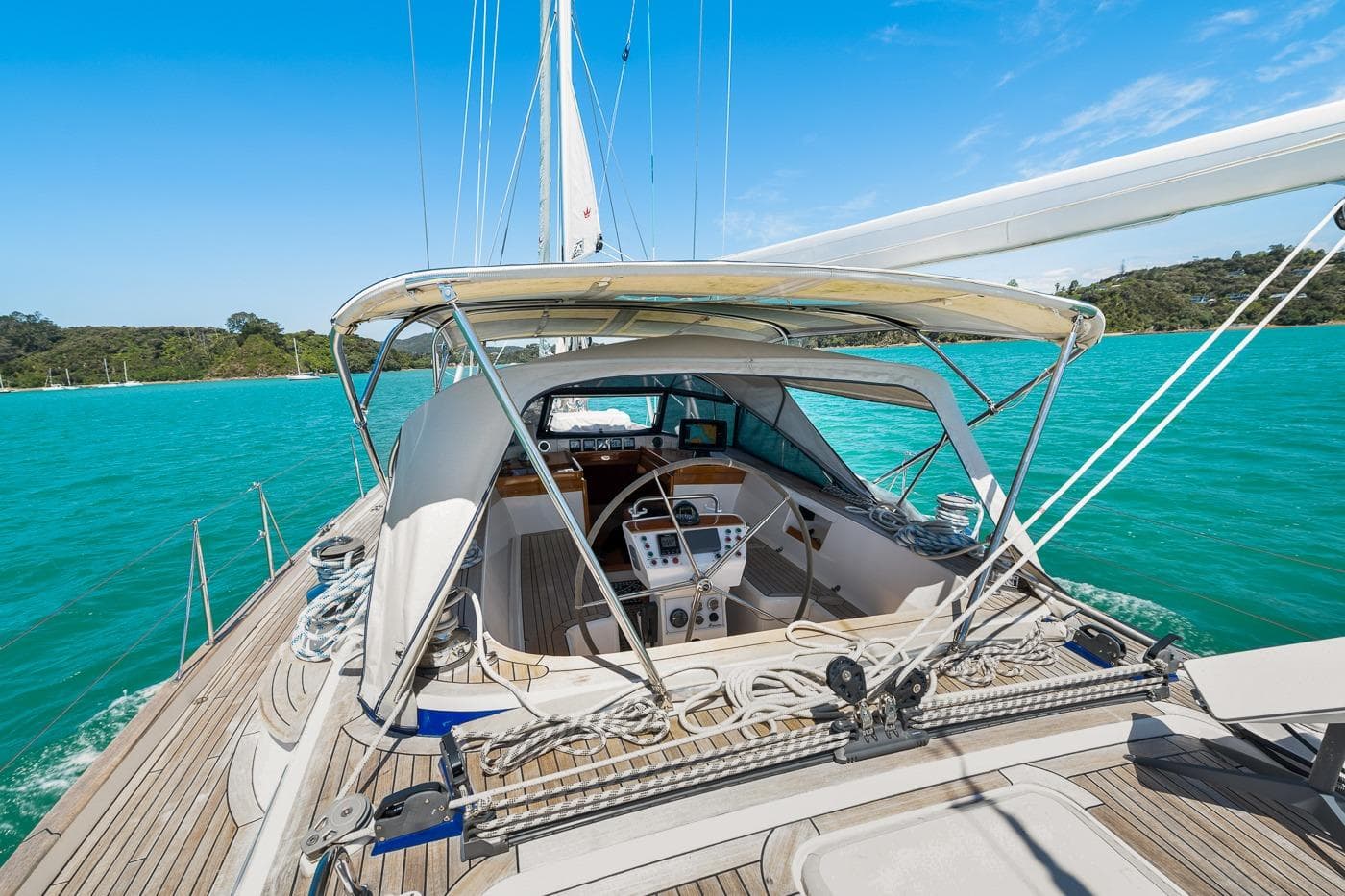 2008 Hallberg-Rassy 54 yacht with canopy, sailing on turquoise waters.