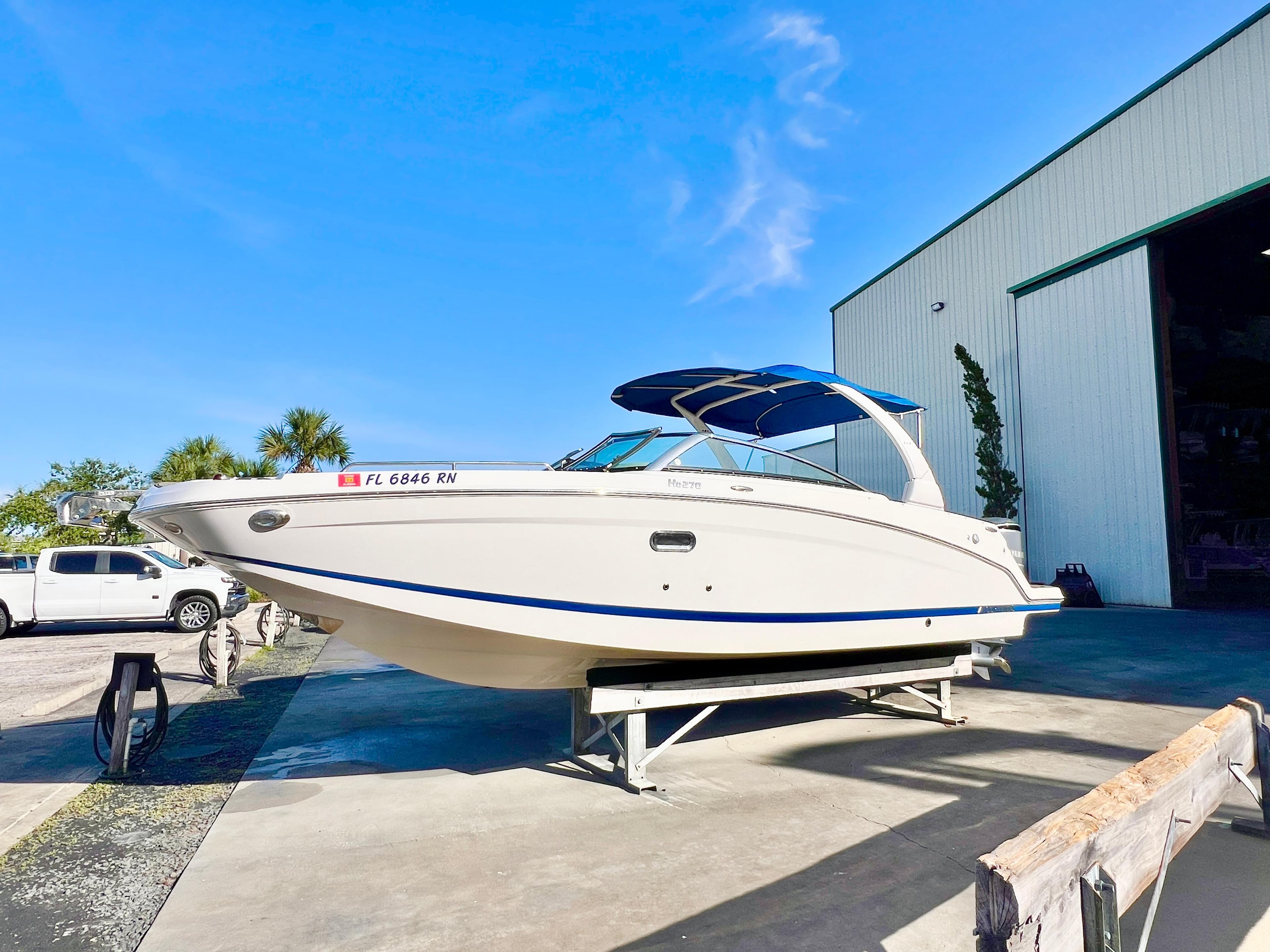 2018 Four Winns HD270 OB boat on trailer outside a large storage facility.