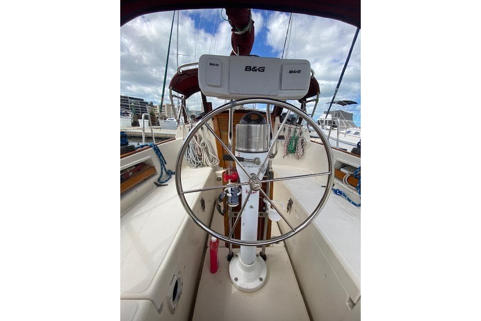 1995 Pacific Seacraft Crealock 34 sailboat cockpit with steering wheel and navigation equipment.