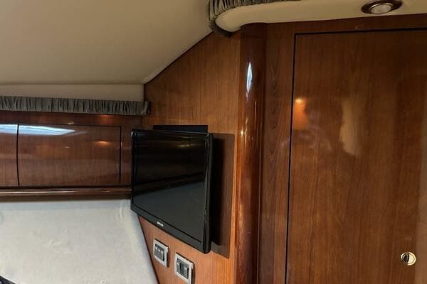 2003 Sea Ray 420 Sundancer interior with wood paneling and mounted TV.
