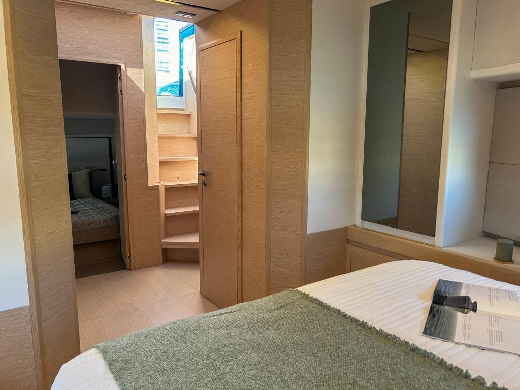 Interior cabin of 2024 Solaris Power 52 Open yacht with wooden finishes and cozy bedding.