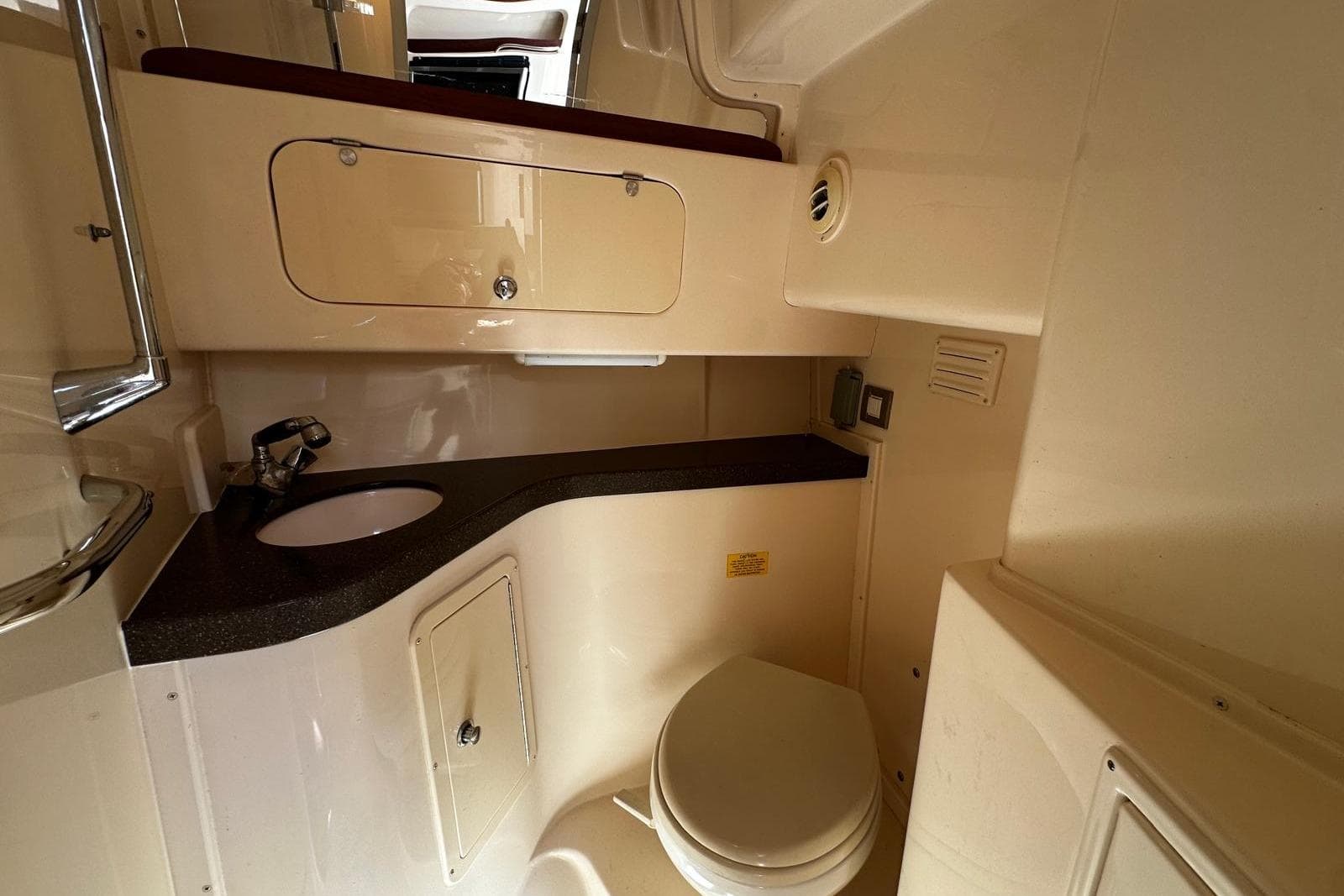 2008 Grady-White Express 330 boat bathroom with sink, toilet, and storage cabinet.