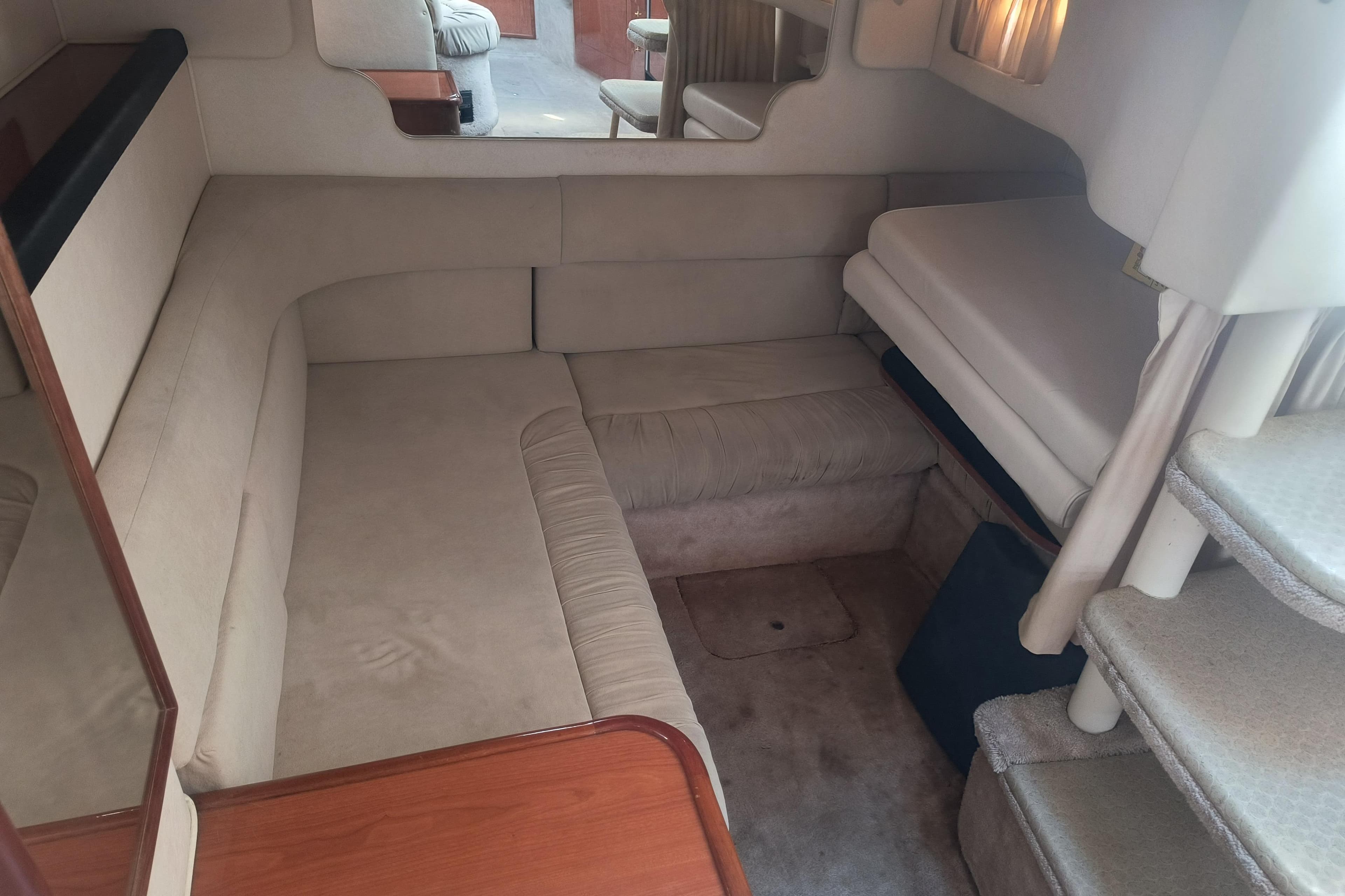 Interior of 2000 Sea Ray 340 Sundancer, featuring cozy seating and carpeted steps.