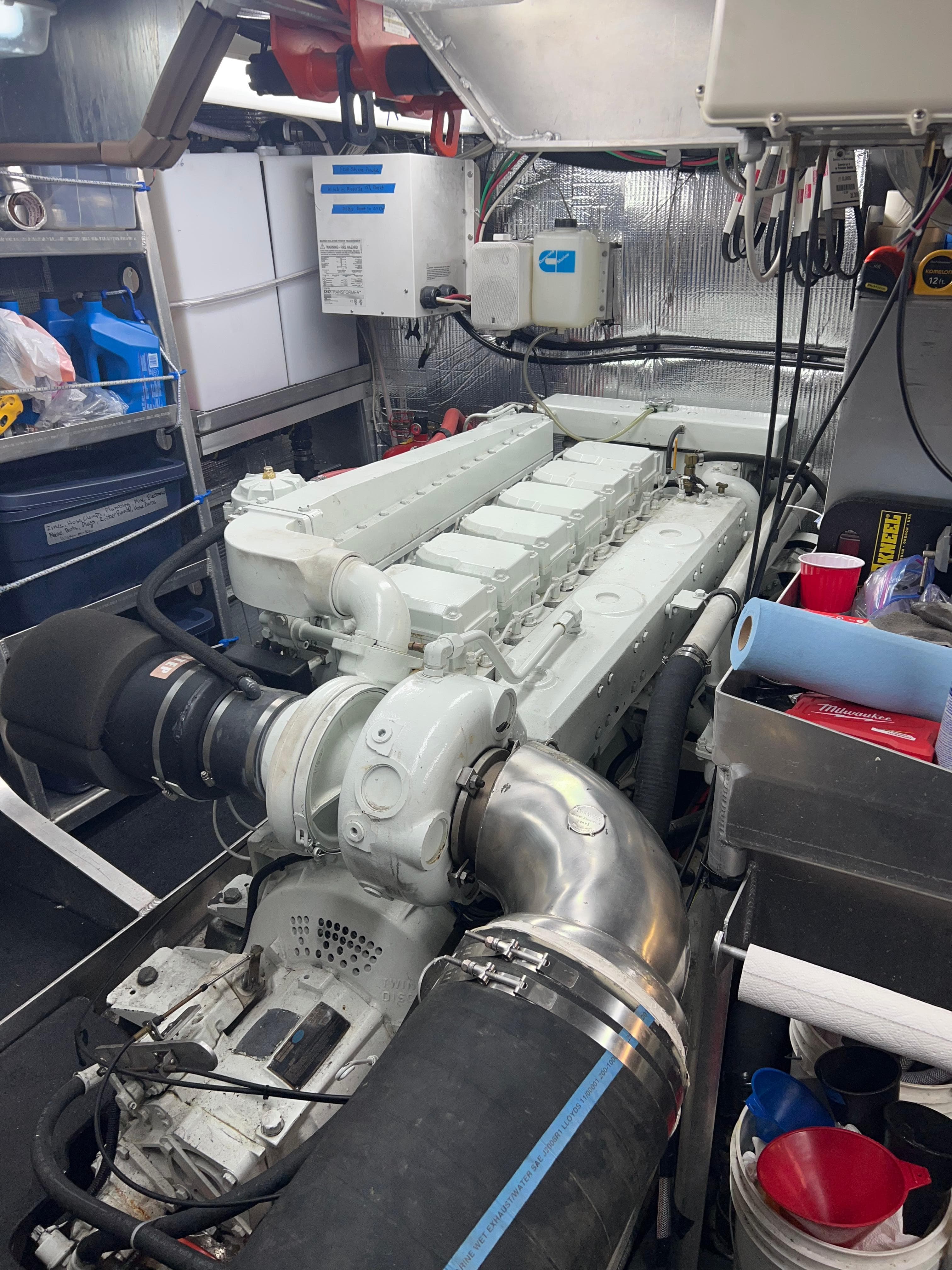 Engine room of a 2003 Peregrine 62 Custom yacht, featuring a large, white engine.