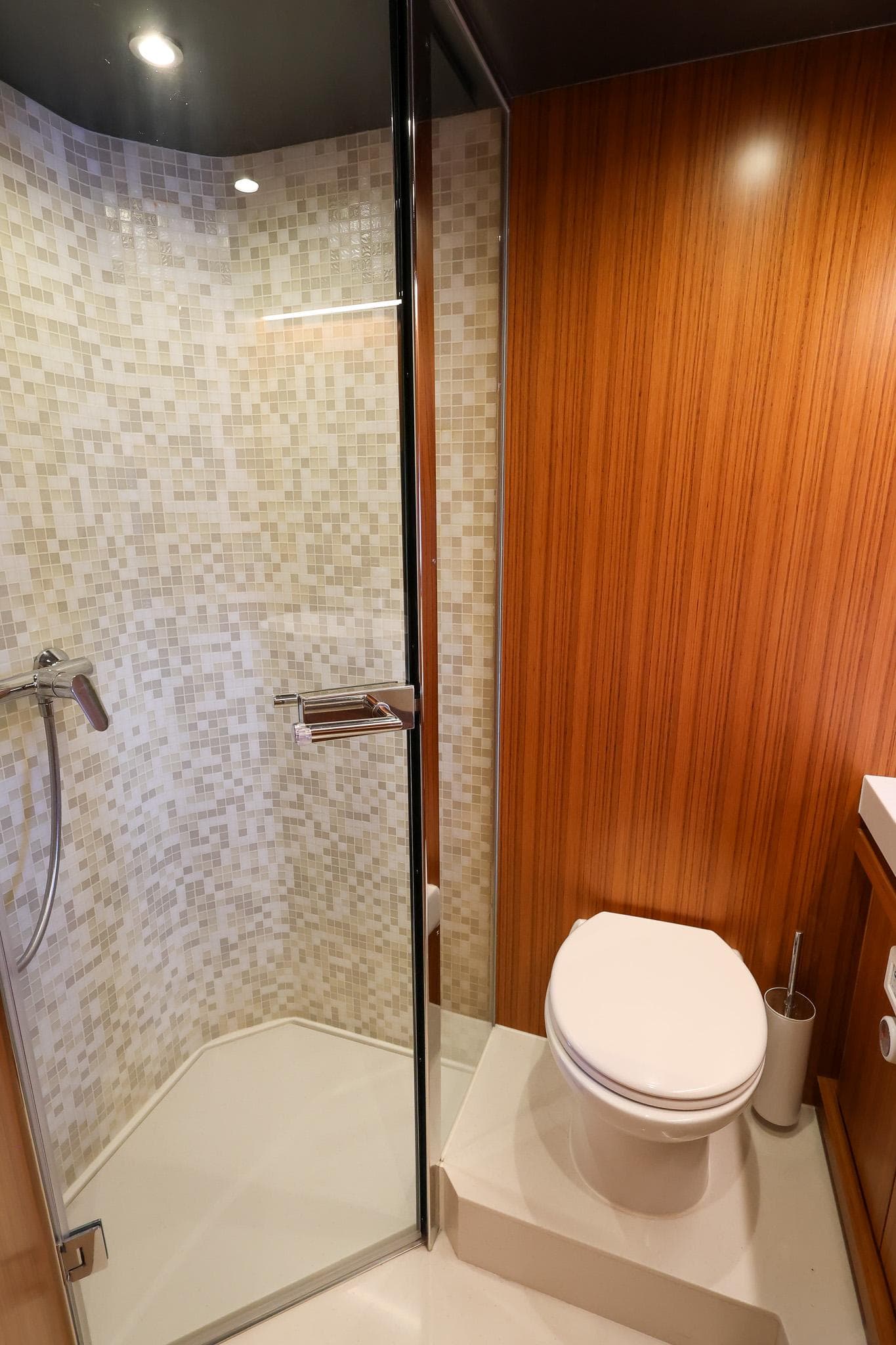 Luxurious bathroom in 2021 Greenline OceanClass 68 yacht with wood paneling and glass shower.