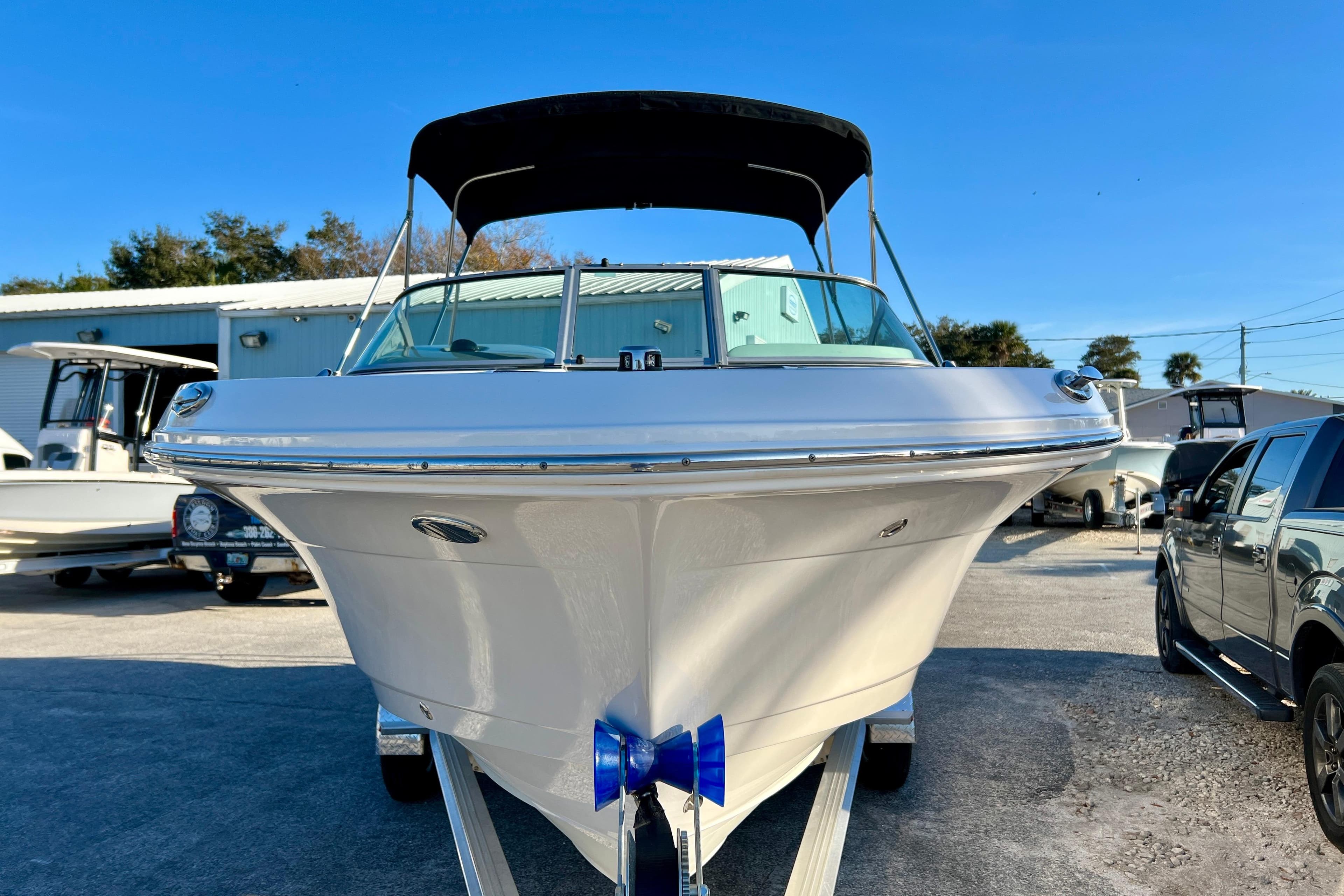 2024 Robalo R207 Dual Console boat on trailer, front view, sunny day.