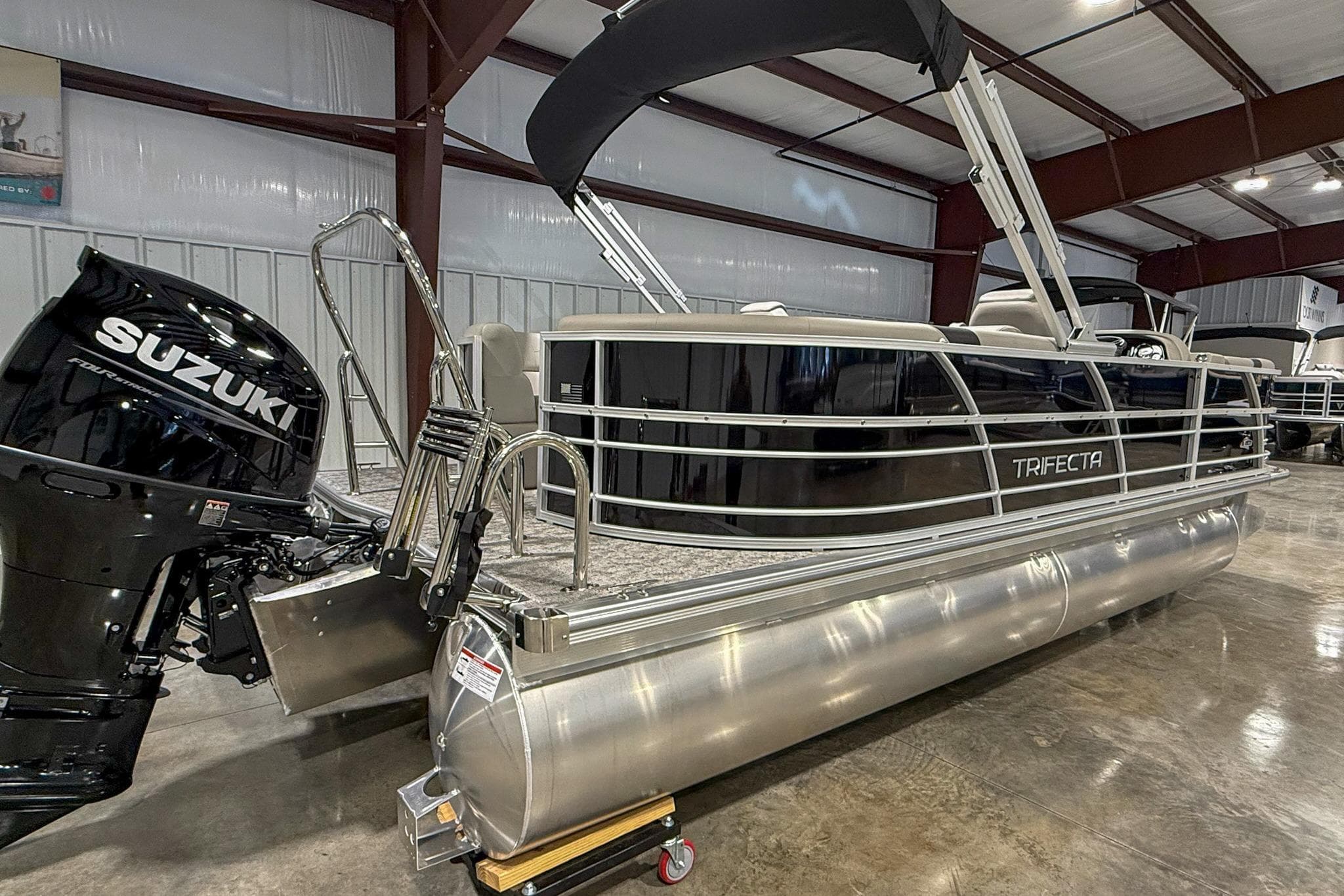 2025 Trifecta 22RF LE pontoon boat with Suzuki outboard motor in a showroom.