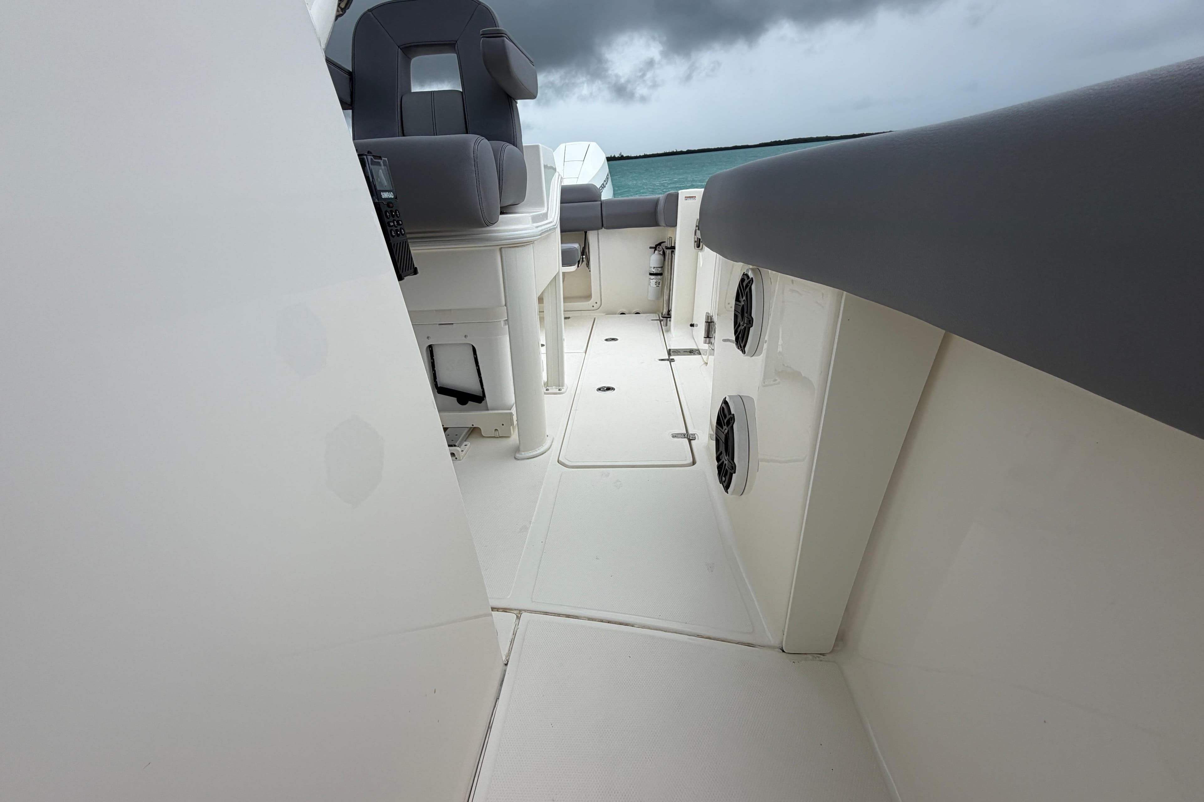 2024 Boston Whaler 280 Outrage interior, showcasing seating and sleek design under cloudy skies.