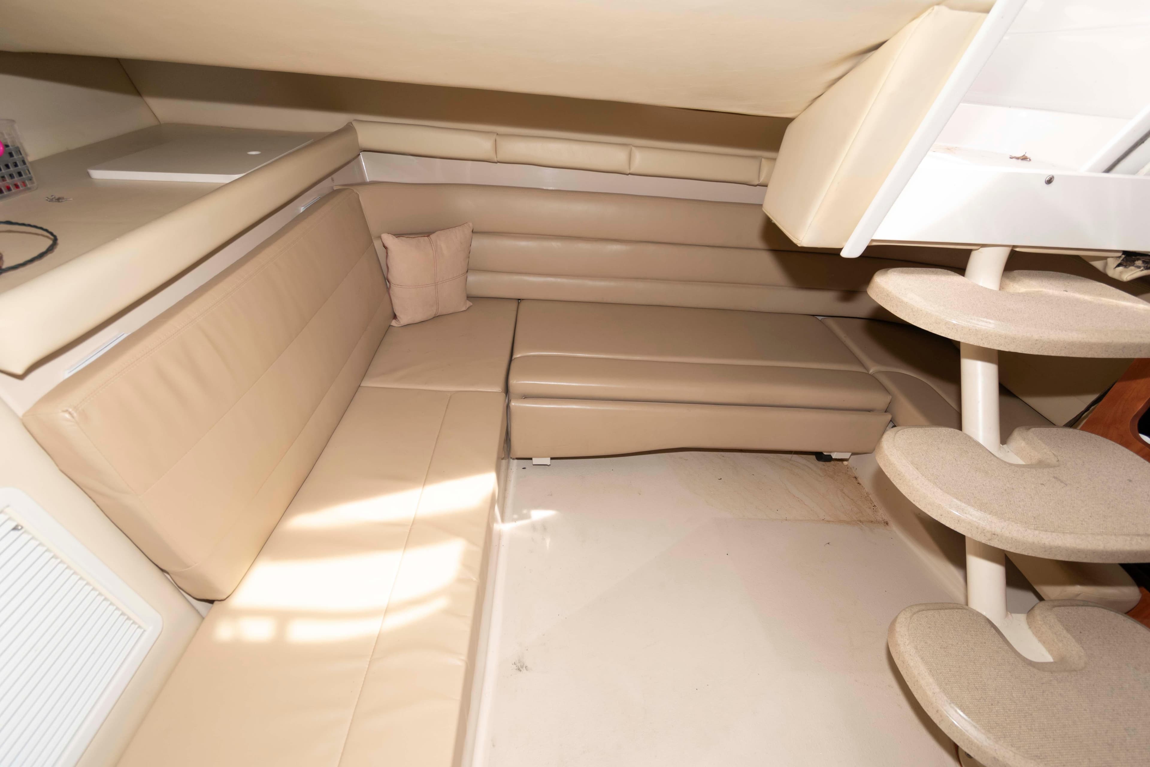 Interior of 2007 Larson Cabrio 370 boat with beige seating and curved steps.