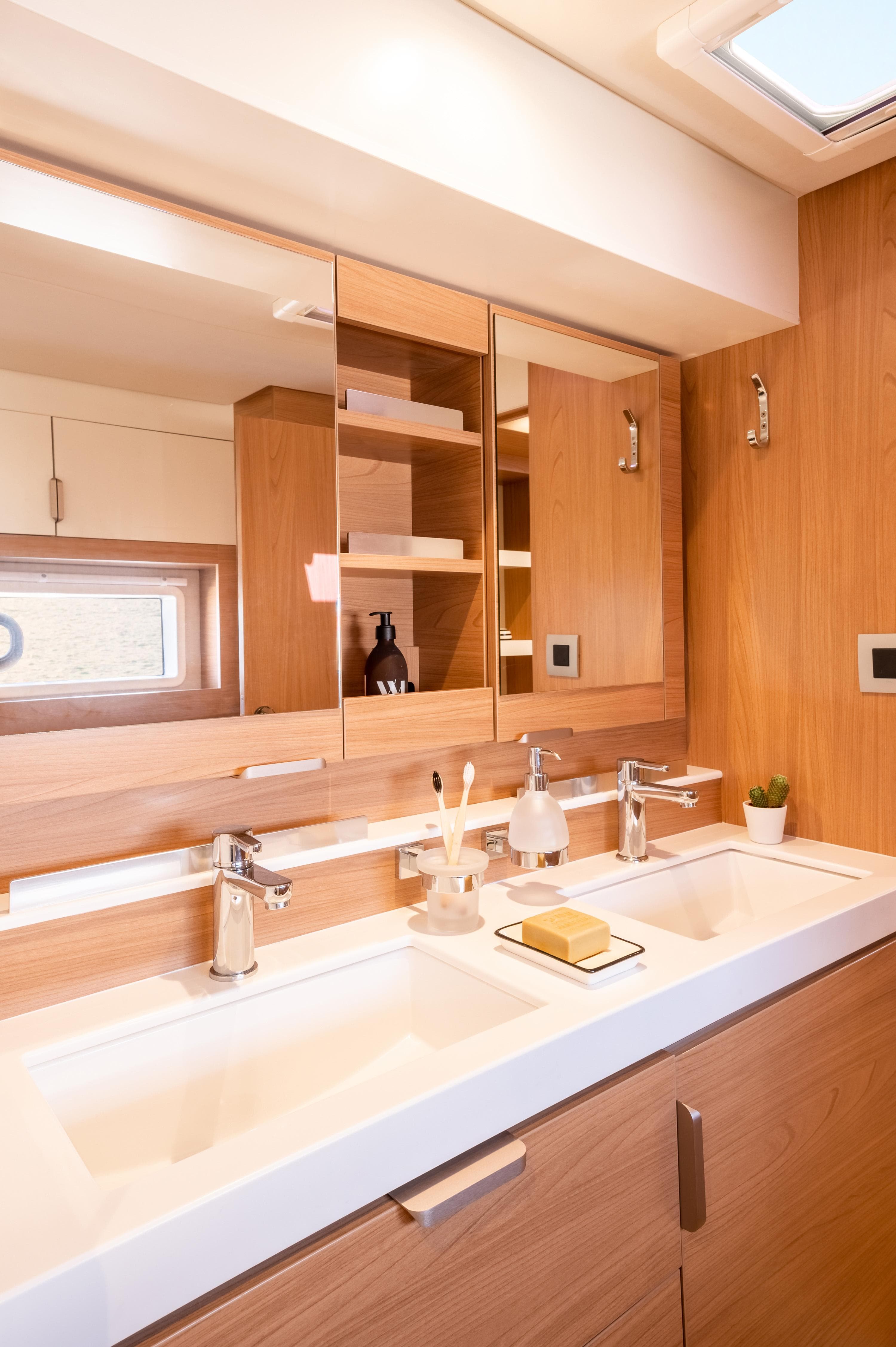 Modern bathroom in 2026 Bali 4.2 yacht with dual sinks and wooden cabinetry.