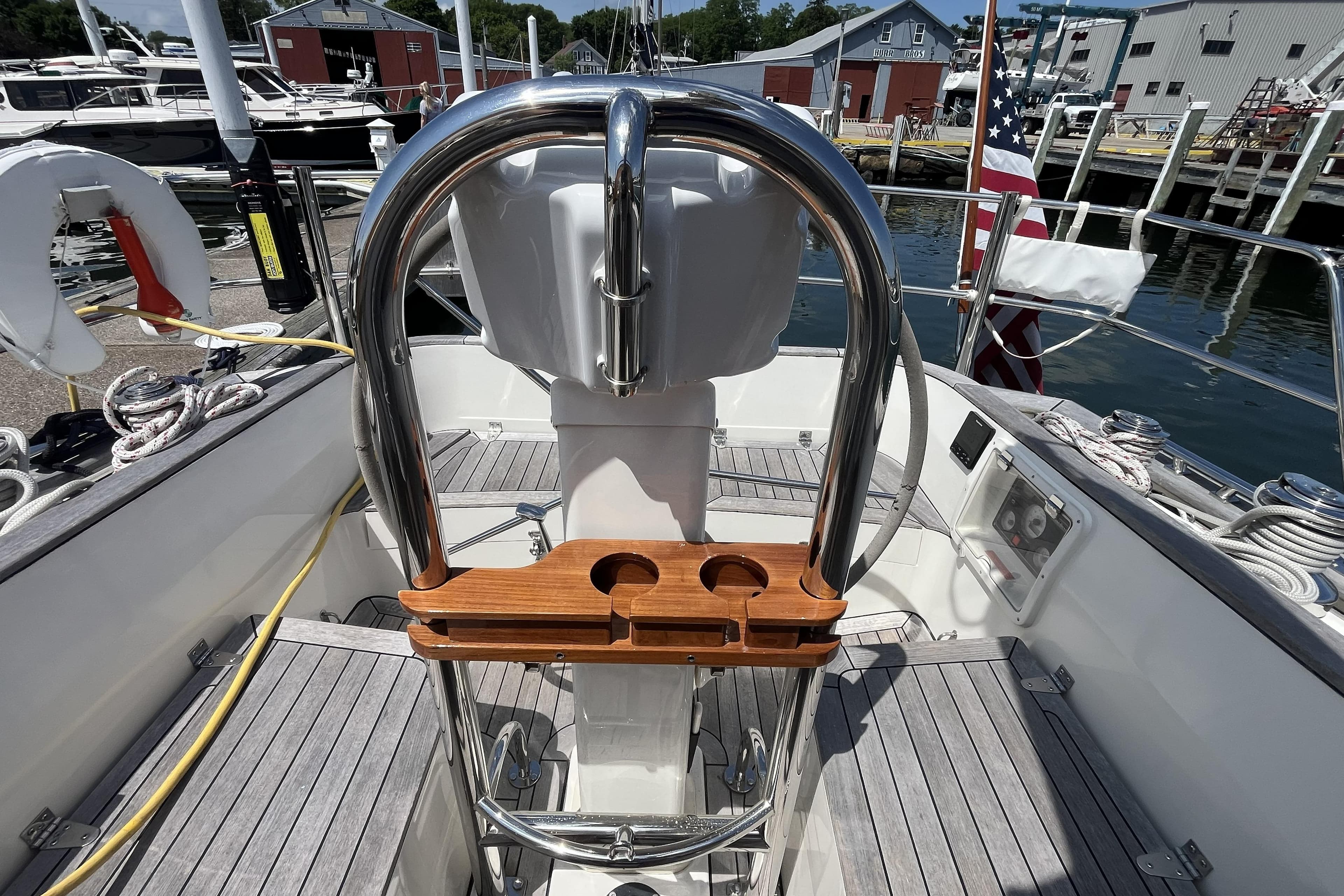 Cockpit of 2017 Rustler 37 sailboat with steering wheel and wooden cup holder.