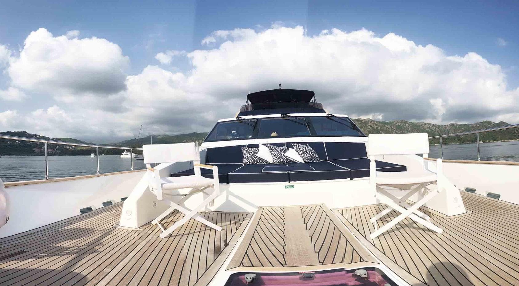 Luxury 2006 Couach 3000 Fly yacht deck with seating, scenic ocean view.