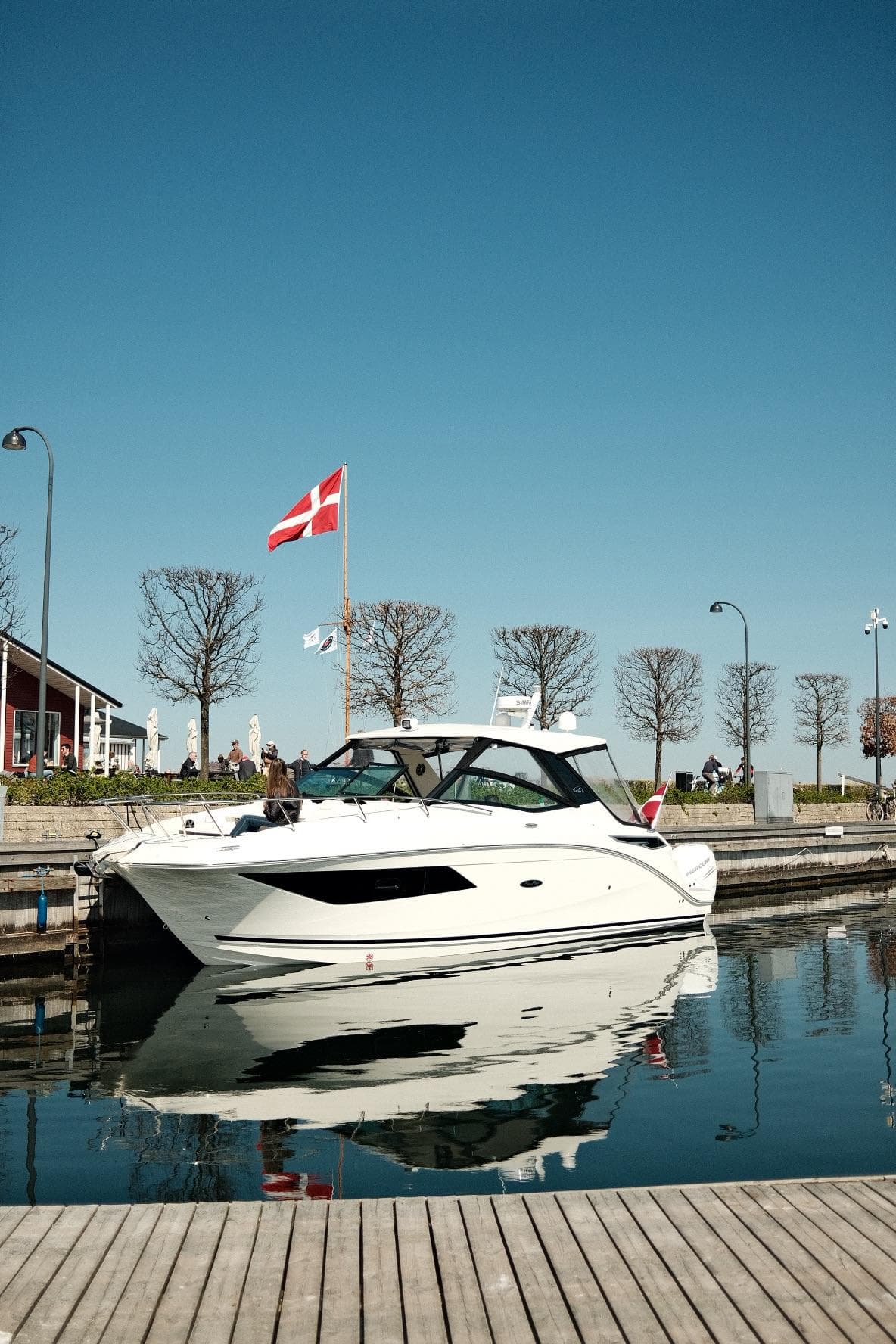 2021 Sea Ray Sundancer 320 Outboard docked in a marina, clear sky, Danish flag visible.