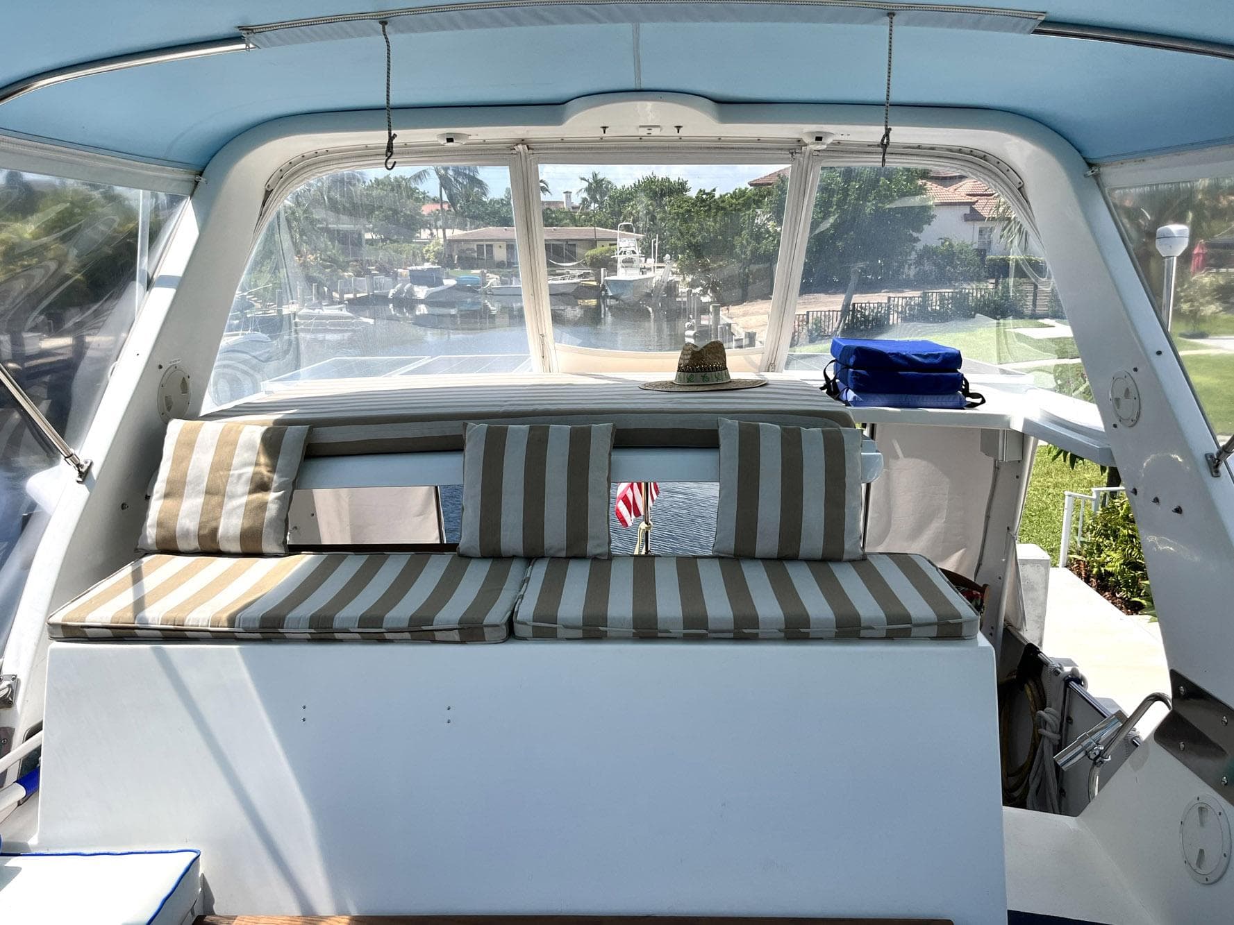1987 Symbol 44 Sun Deck MK II with striped seating and clear canopy, docked in a marina.