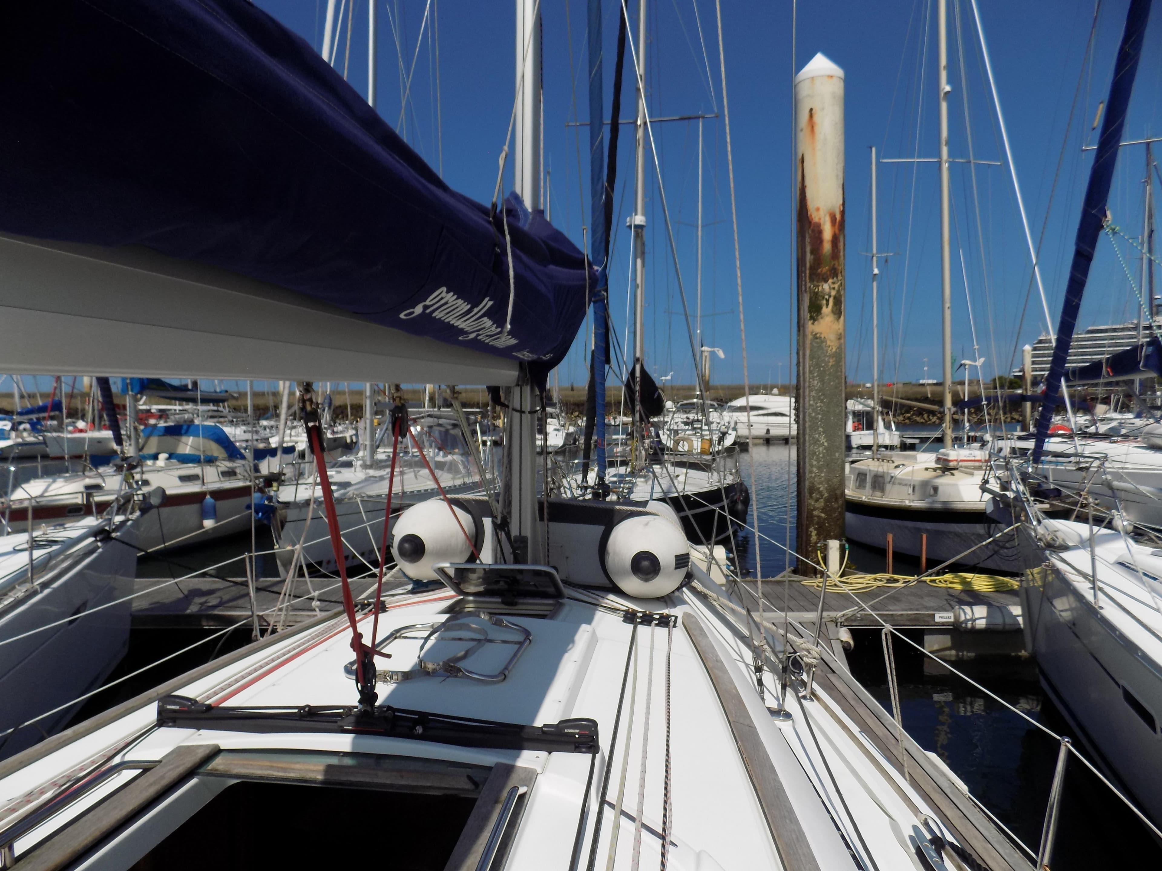 2009 Beneteau Oceanis 43 sailboat docked in a marina, surrounded by other boats.