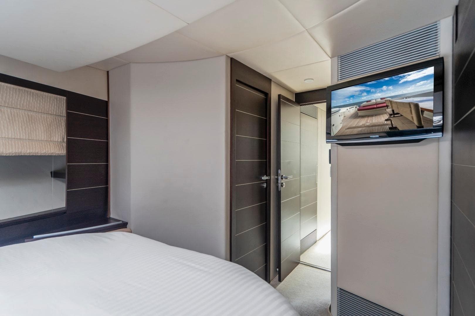 Luxurious bedroom interior of 2007 Azimut 68S yacht with modern decor and wall-mounted TV.