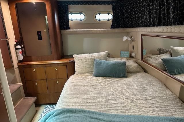 Luxurious 2001 Cruisers Yachts 3750 Motoryacht bedroom with cozy bedding and elegant wood cabinetry.