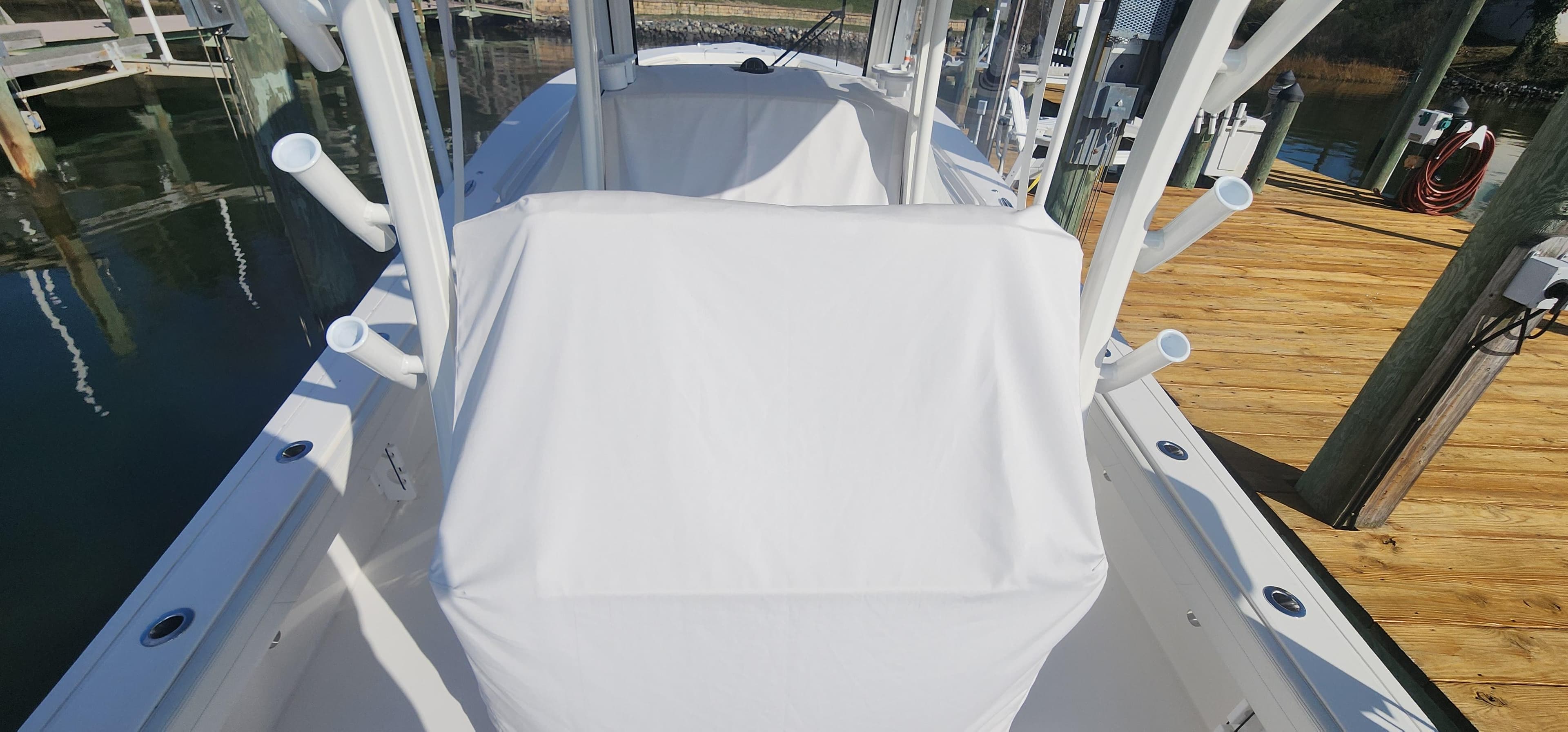 2023 Regulator 30XO Center Console boat docked, covered console, rod holders, and wooden dock.