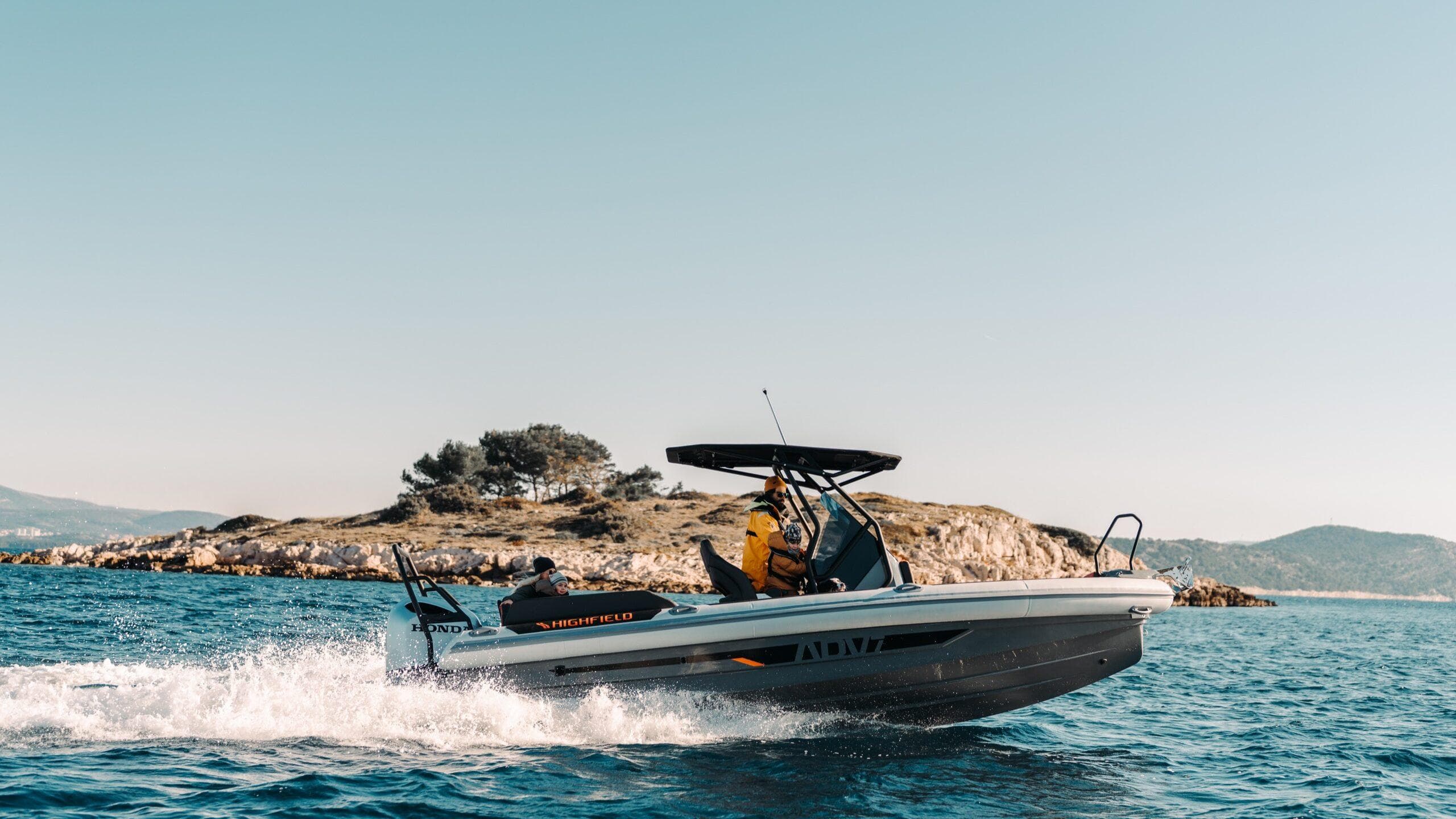 2025 Highfield ADV7 boat cruising near a scenic island under clear skies.