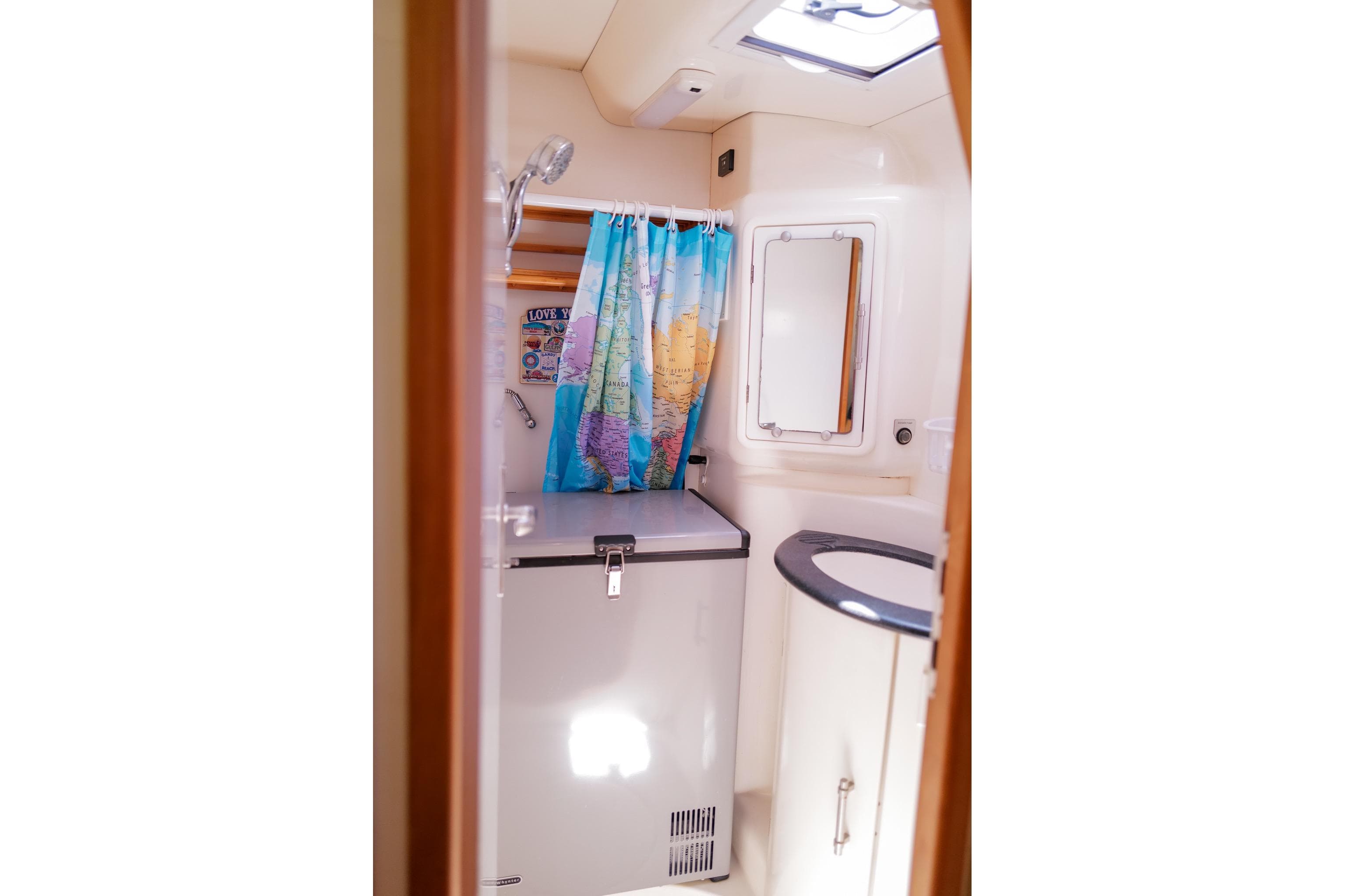 Bathroom interior of a 2006 Leopard 43 yacht with map-themed shower curtain.