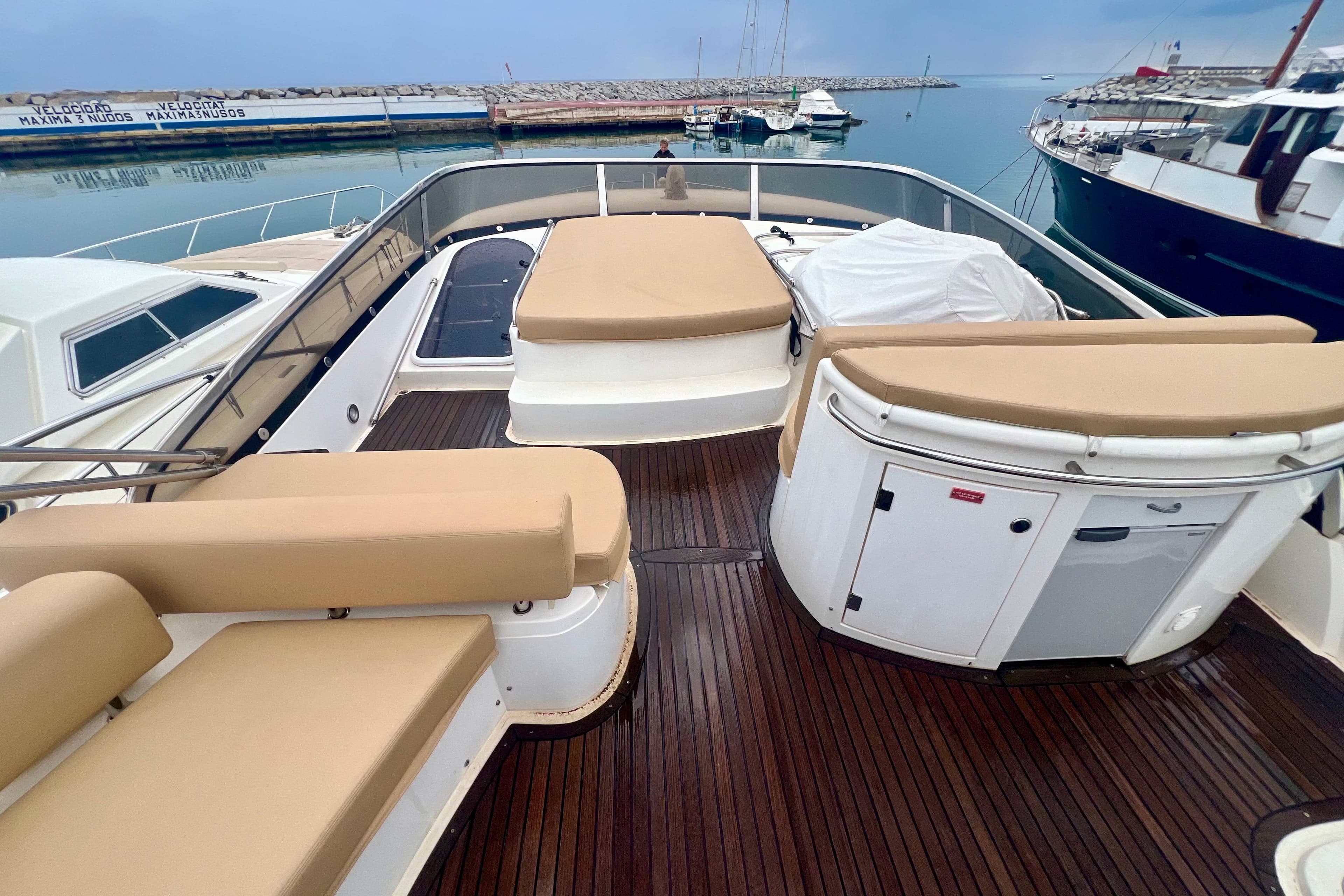 Luxurious 2002 Sunseeker Manhattan 64 yacht deck with cushioned seating and sleek design.