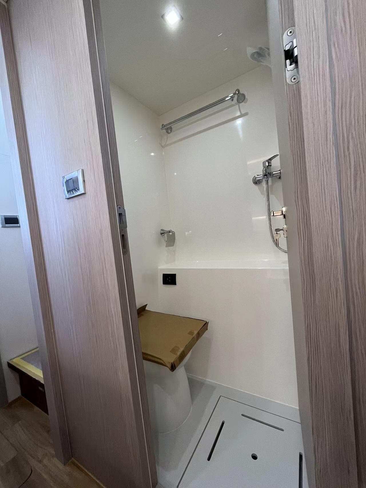 Interior of Mazarin 55 Catamaran 2023, modern shower with wood accents.