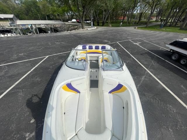 2002 VIP 2400 Vindicator boat with white and yellow interior, parked in a lot.