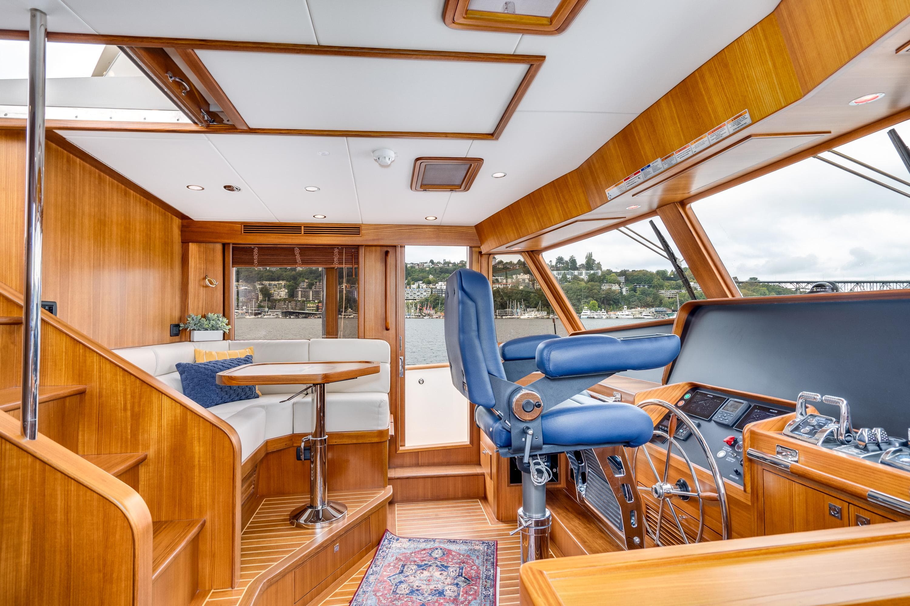 2024 Fleming 58 Pilothouse interior with helm, seating, and wooden finishes.